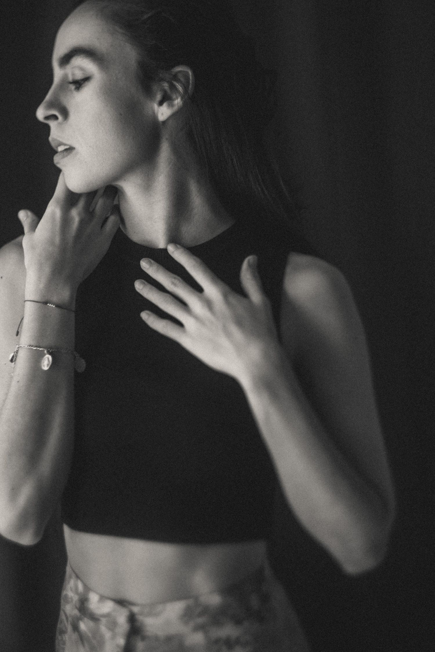 Artistic black and white portraits focusing on hands touching face and neck.