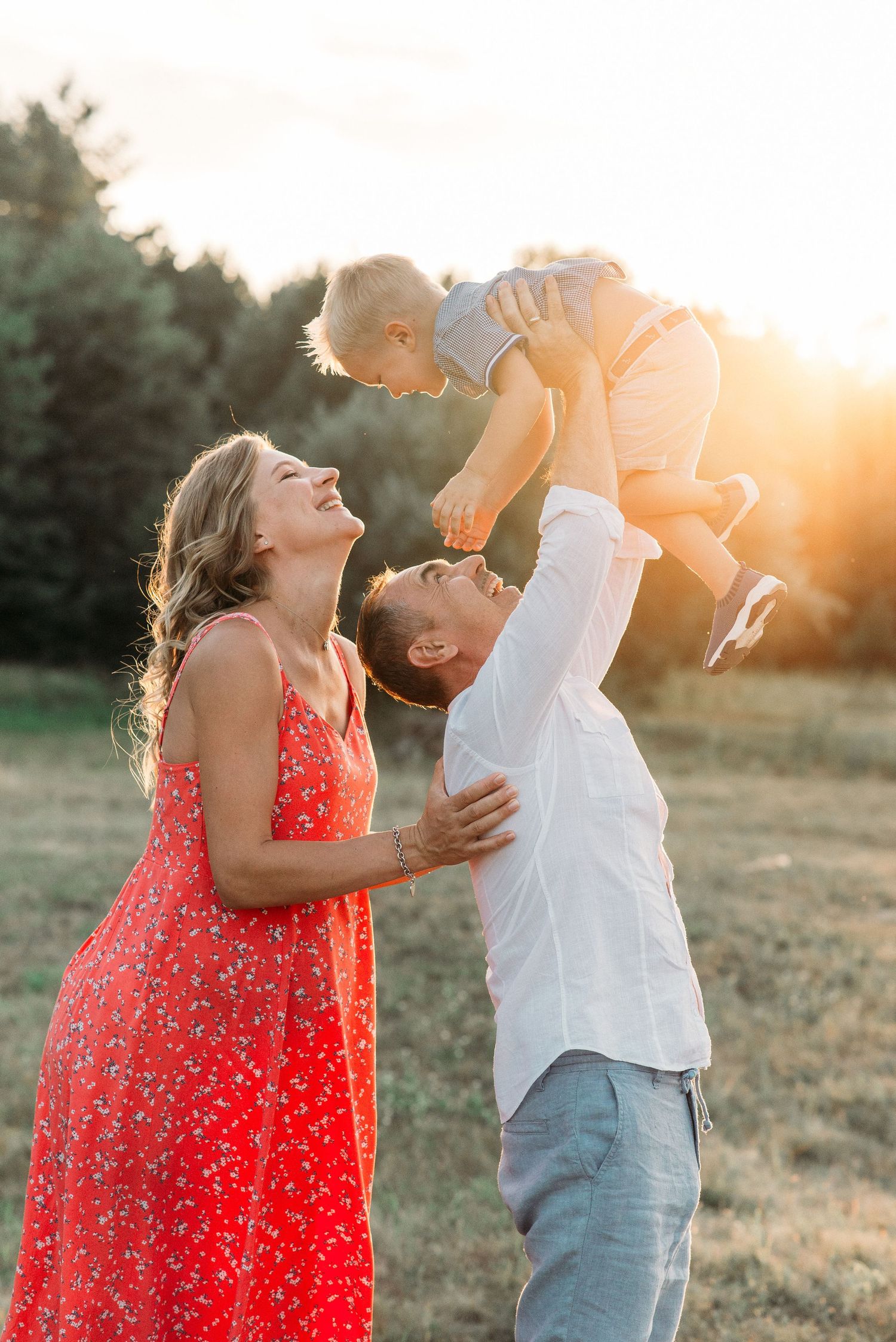 Family playing together in golden sunset light outdoors.