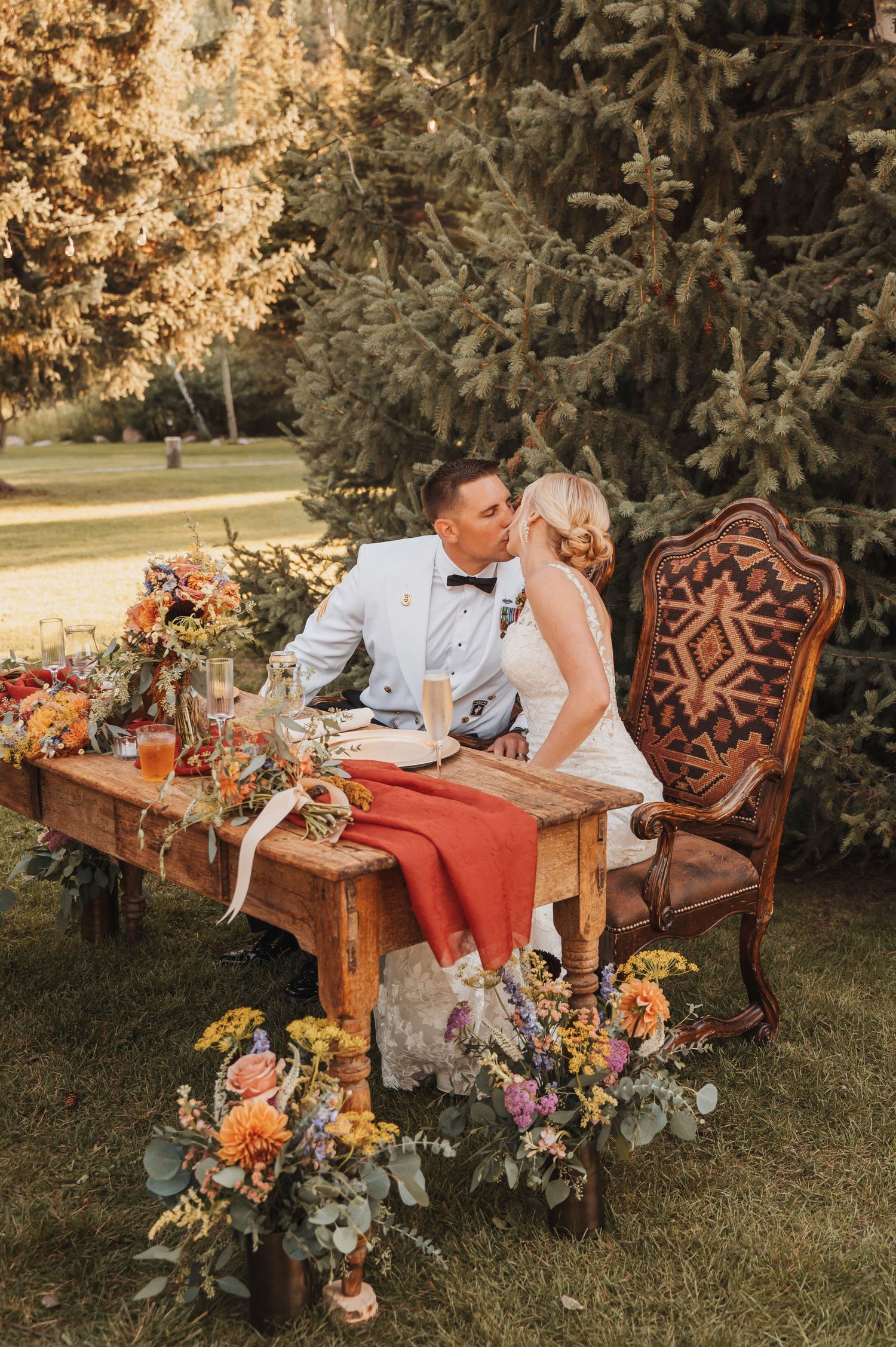 Bride and groom kissing at their wedding table.