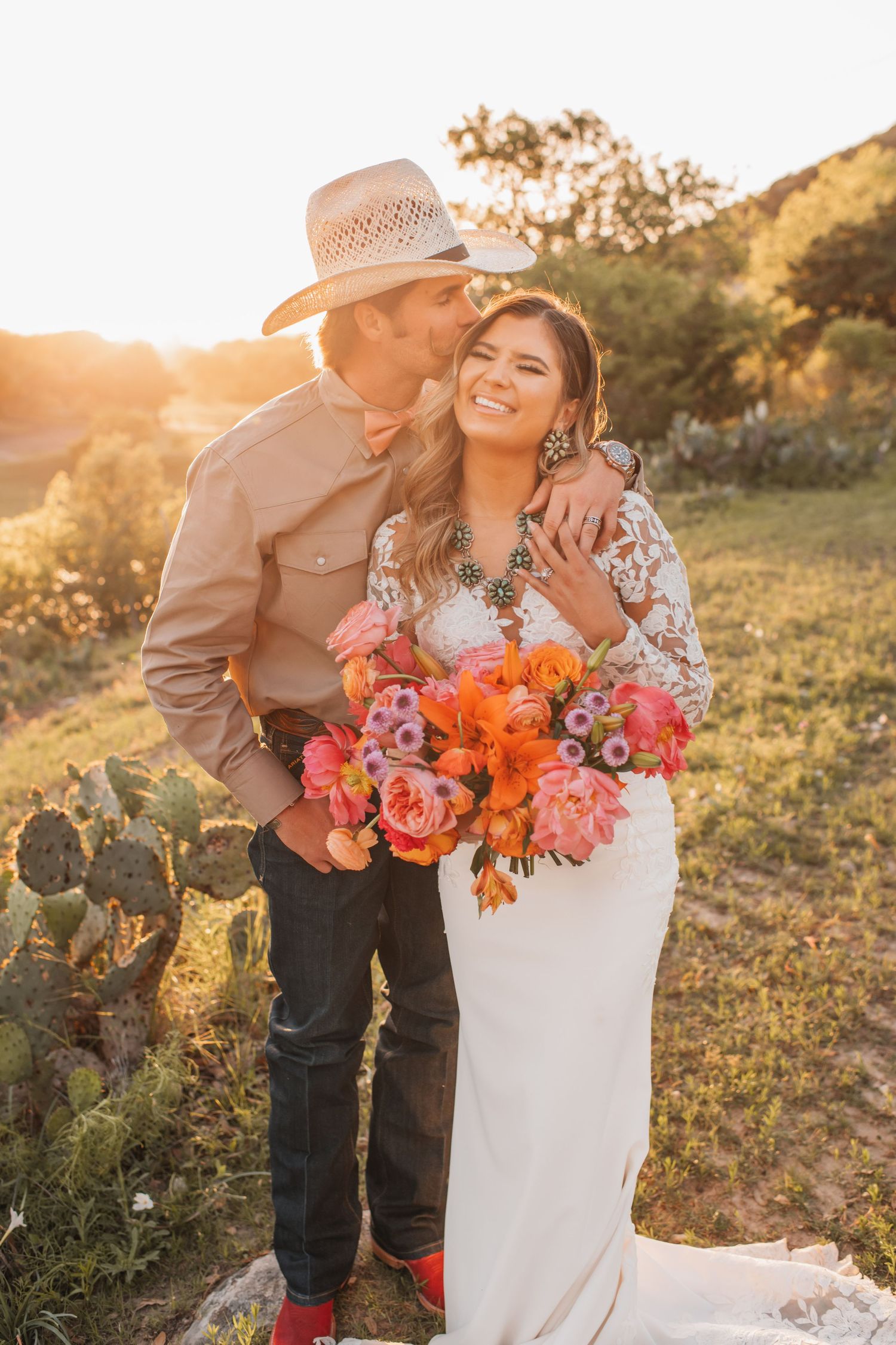 A couple embracing and smiling in front of a picturesque mountain backdrop.
