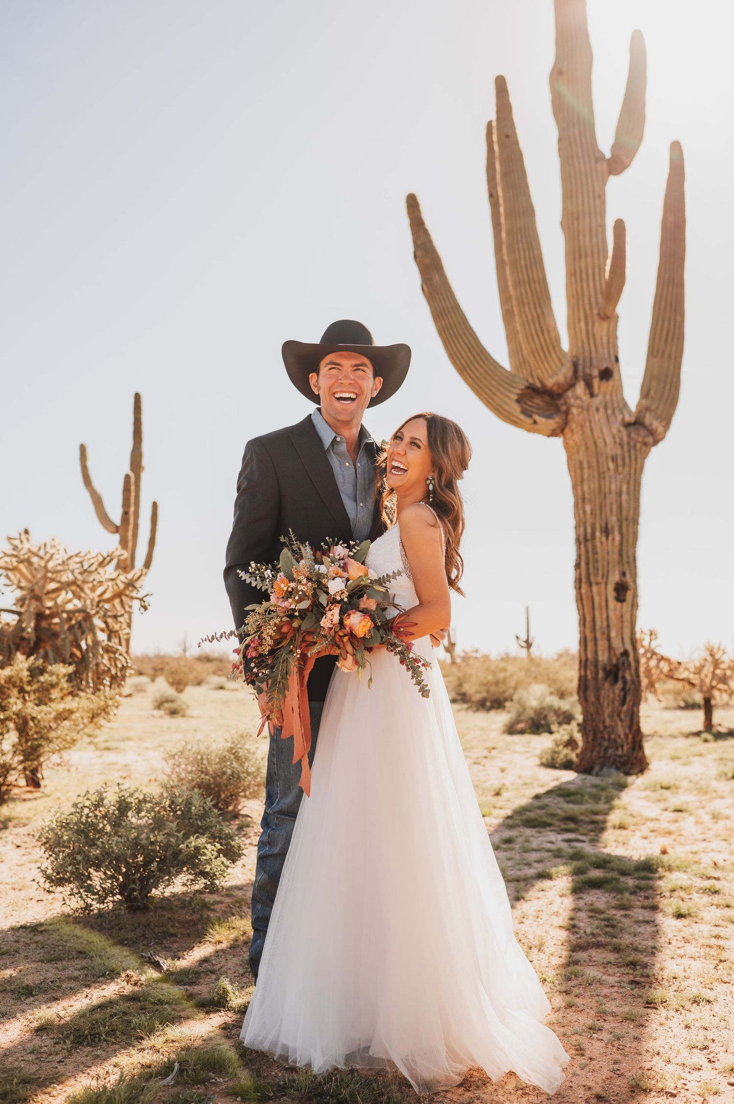 Bride and groom smiling and laughing in the desert