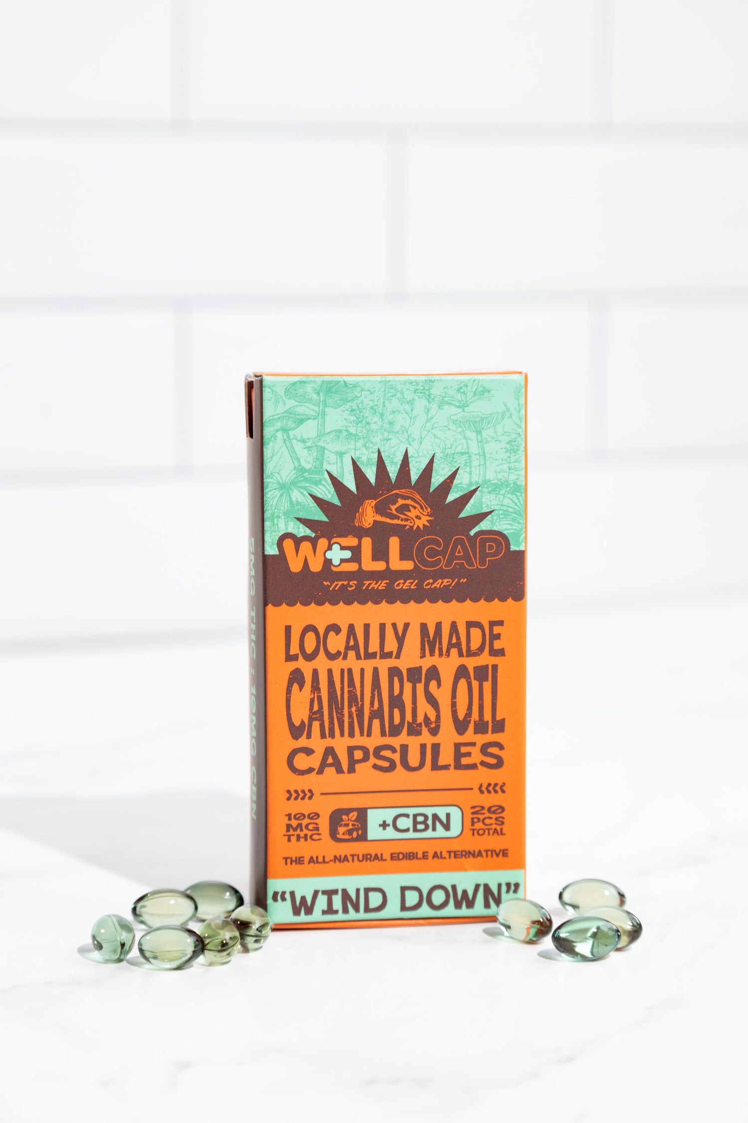 Cannabis product packaging with green and orange design for locally made capsules.