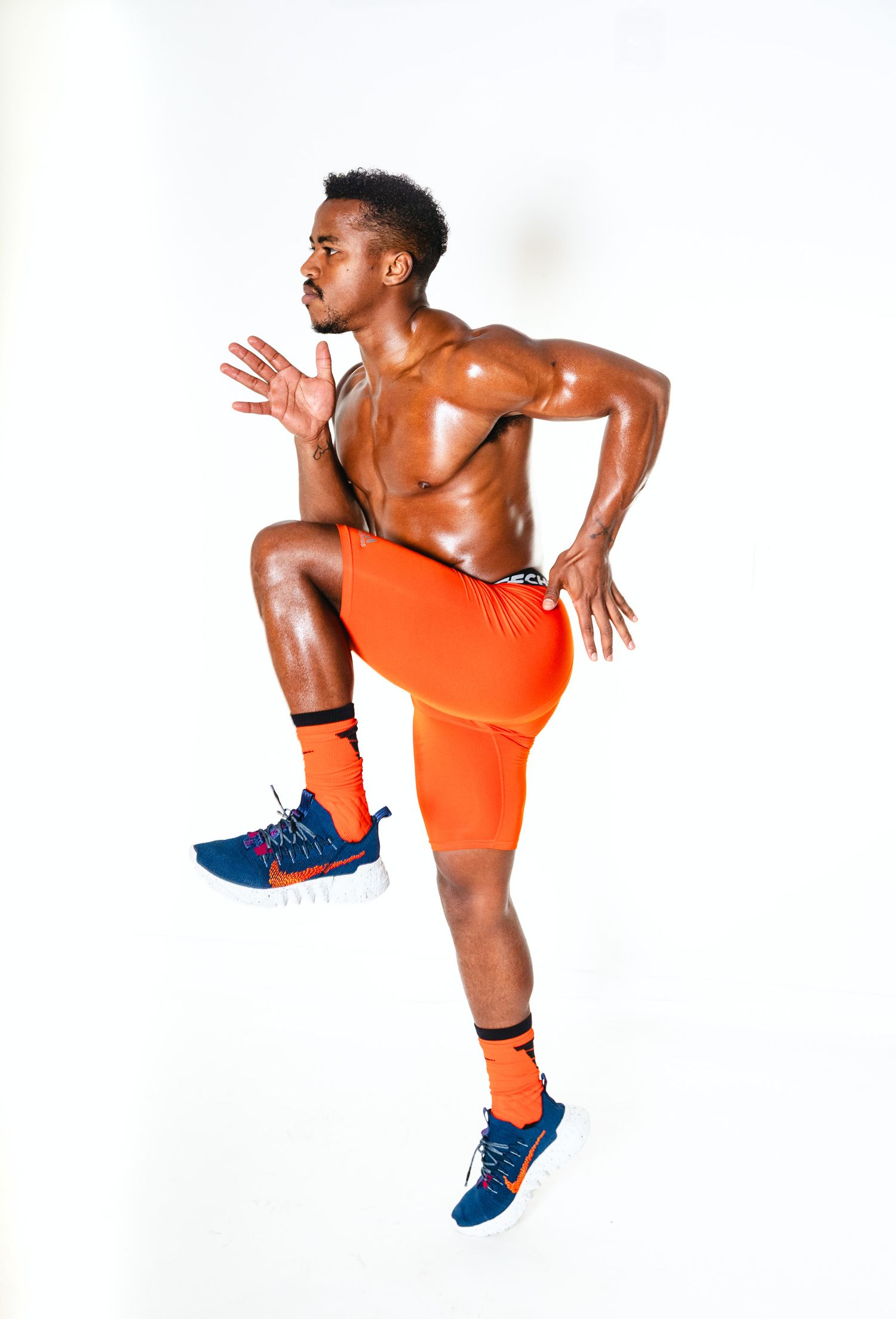 Athletic figure in orange shorts and blue shoes performs dynamic jumping sequence against white background.