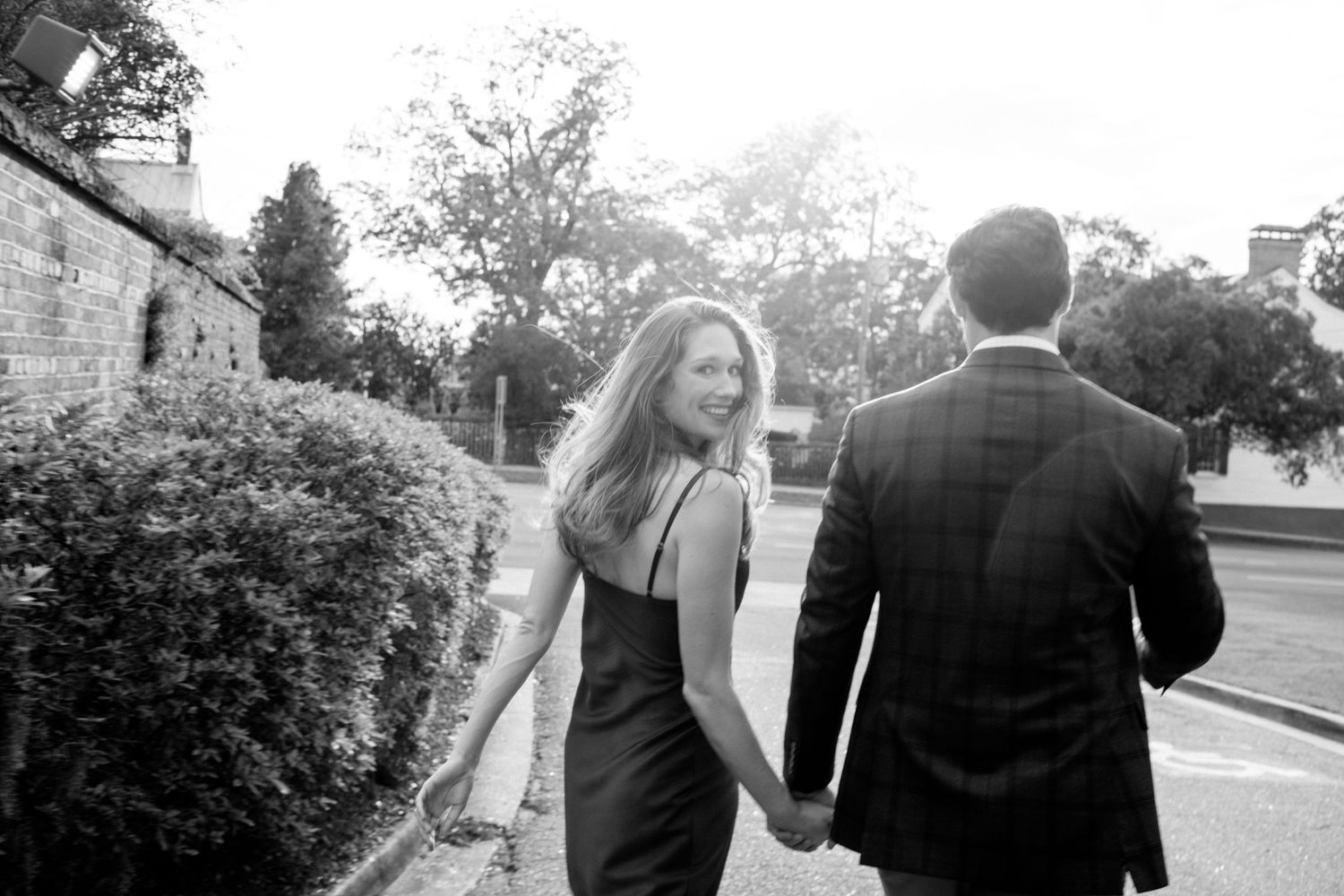 A series of romantic wedding photographs show a couple walking together in a garden setting.