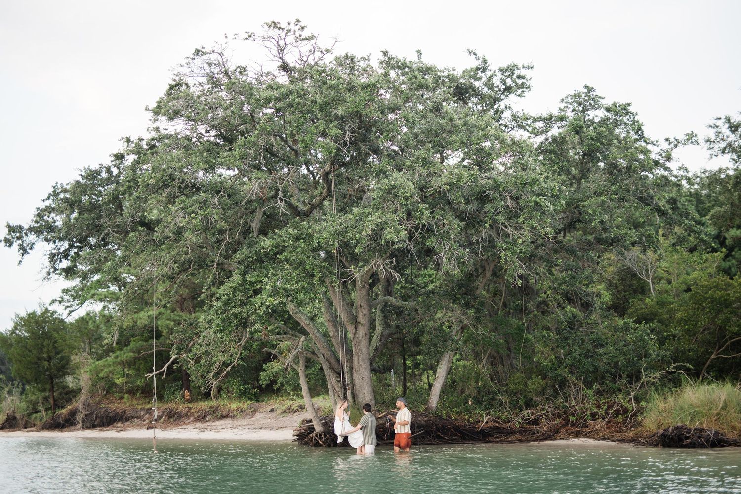 Aerial view of mangrove trees and waterways along a tropical coastline with a small boat visible in the distance.