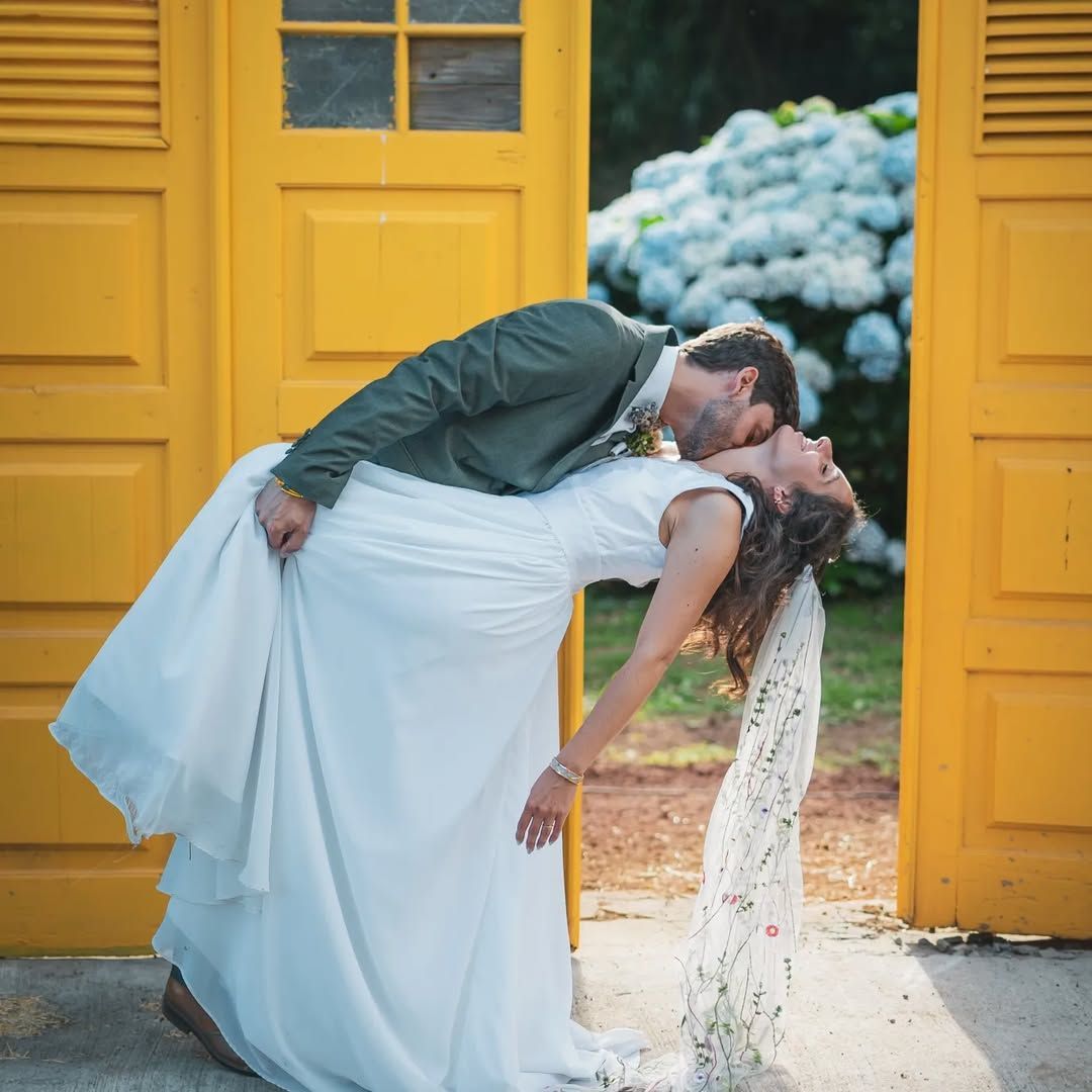 Groom dipping bride in front of yellow doors – colorful destination wedding in the Azores