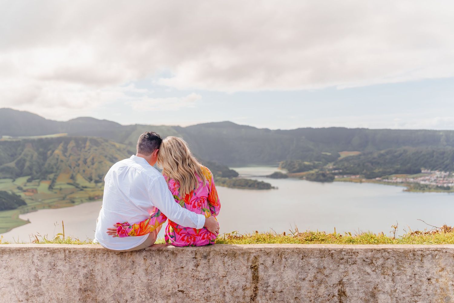 Engaged couple seated on viewpoint at Sete Cidades – romantic moment in Azores proposal session
