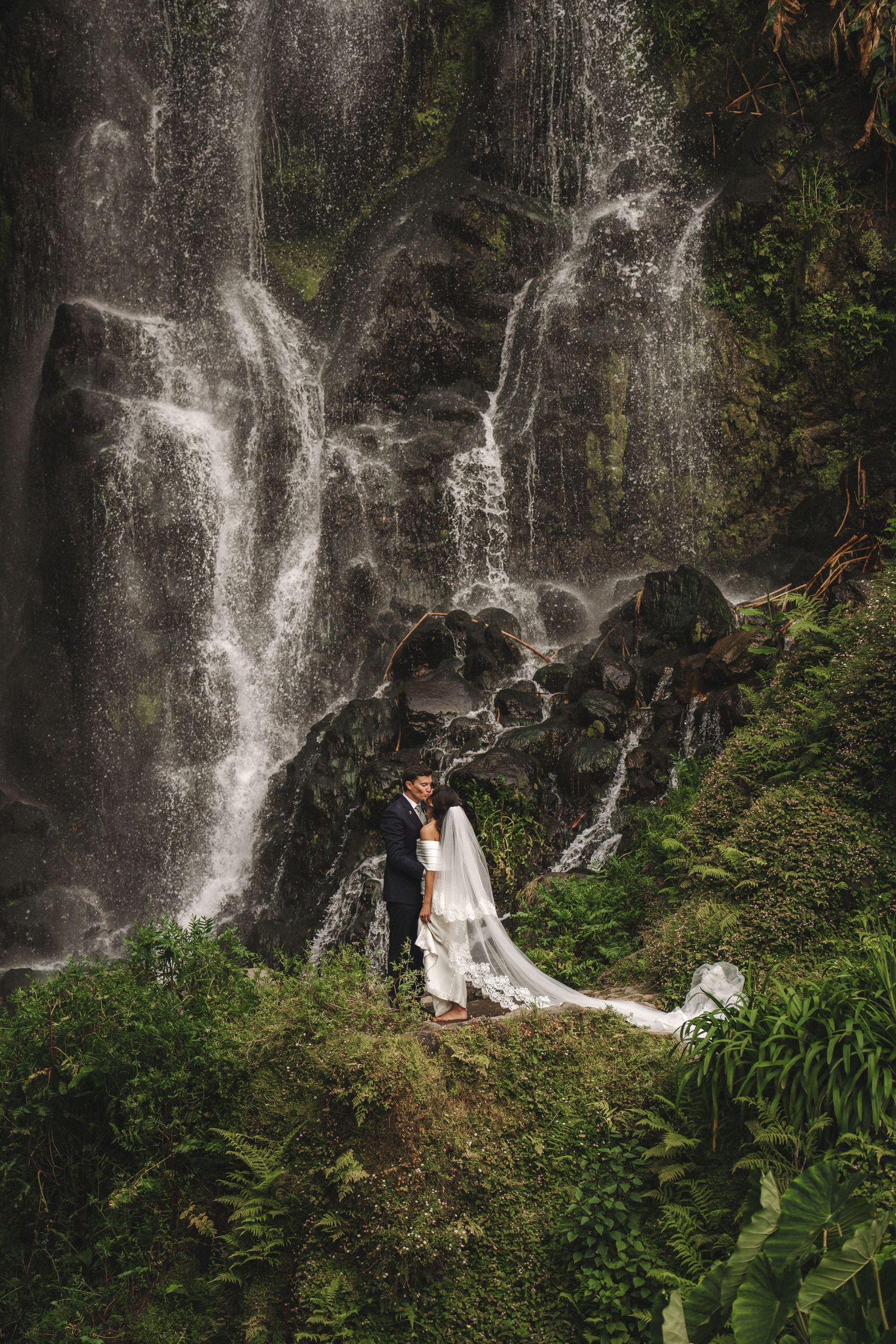 Couple near waterfall – dramatic elopement scene by São Miguel wedding photographer