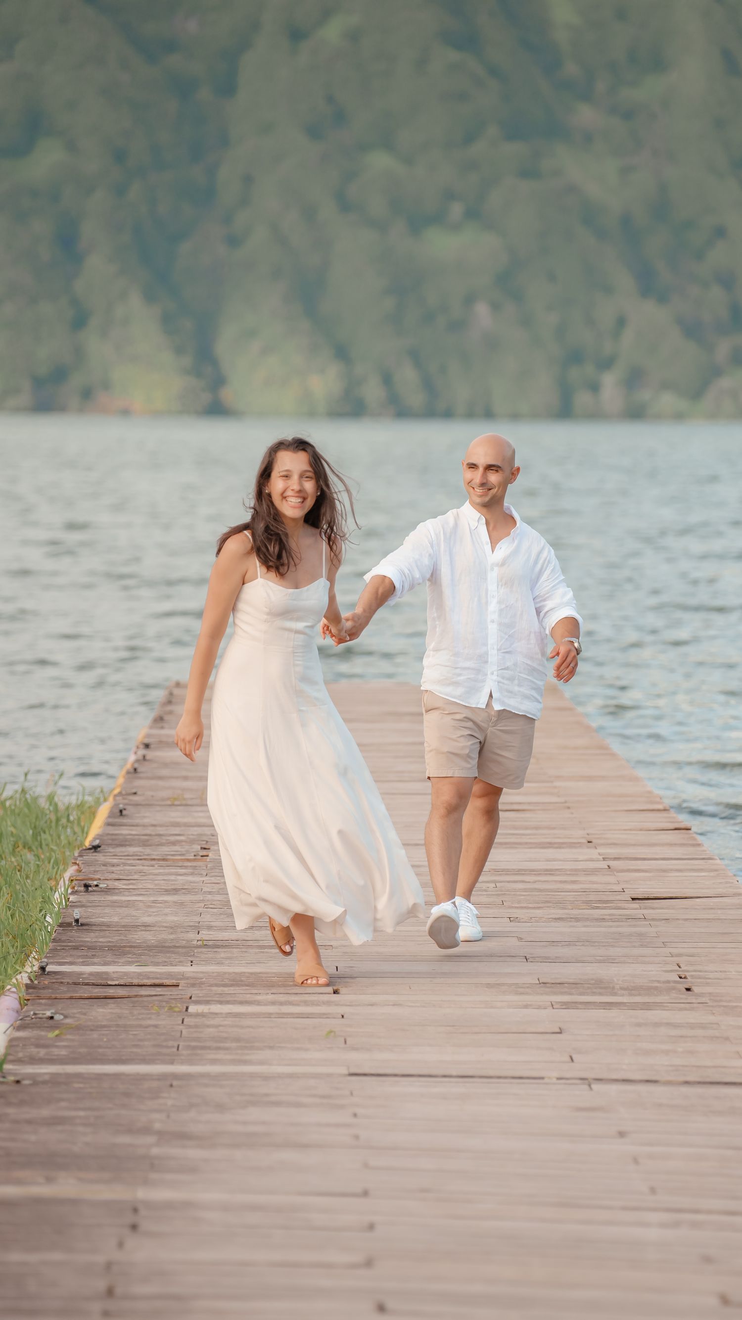 Bride and groom walking down wooden dock – cinematic wedding photo at Lagoa das Sete Cidades