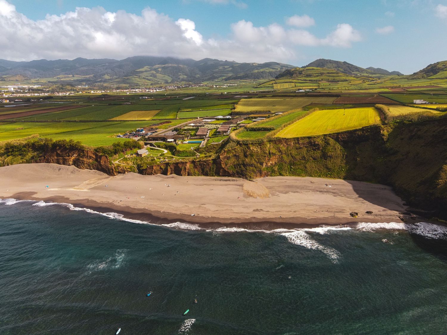 Aerial panoramic view of rugged coastal cliffs meeting sandy beaches along the scenic Scottish coastline.