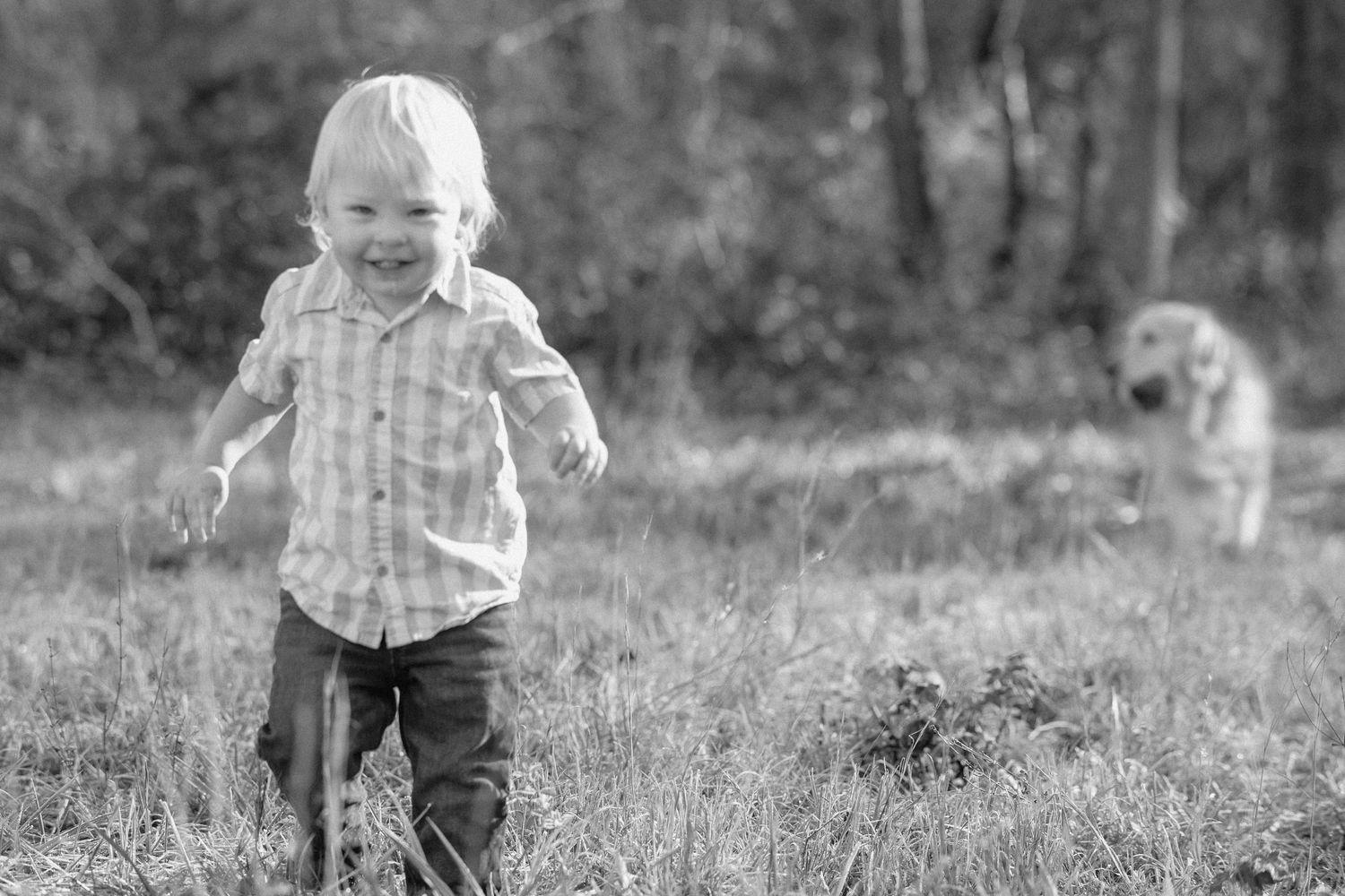 A series of black and white photos showing a toddler playing and running in a grassy outdoor field.