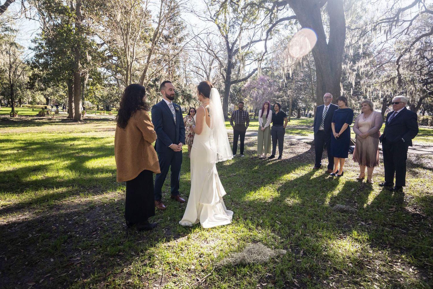 Outdoor wedding ceremony photos taken in natural sunlight filtering through trees.