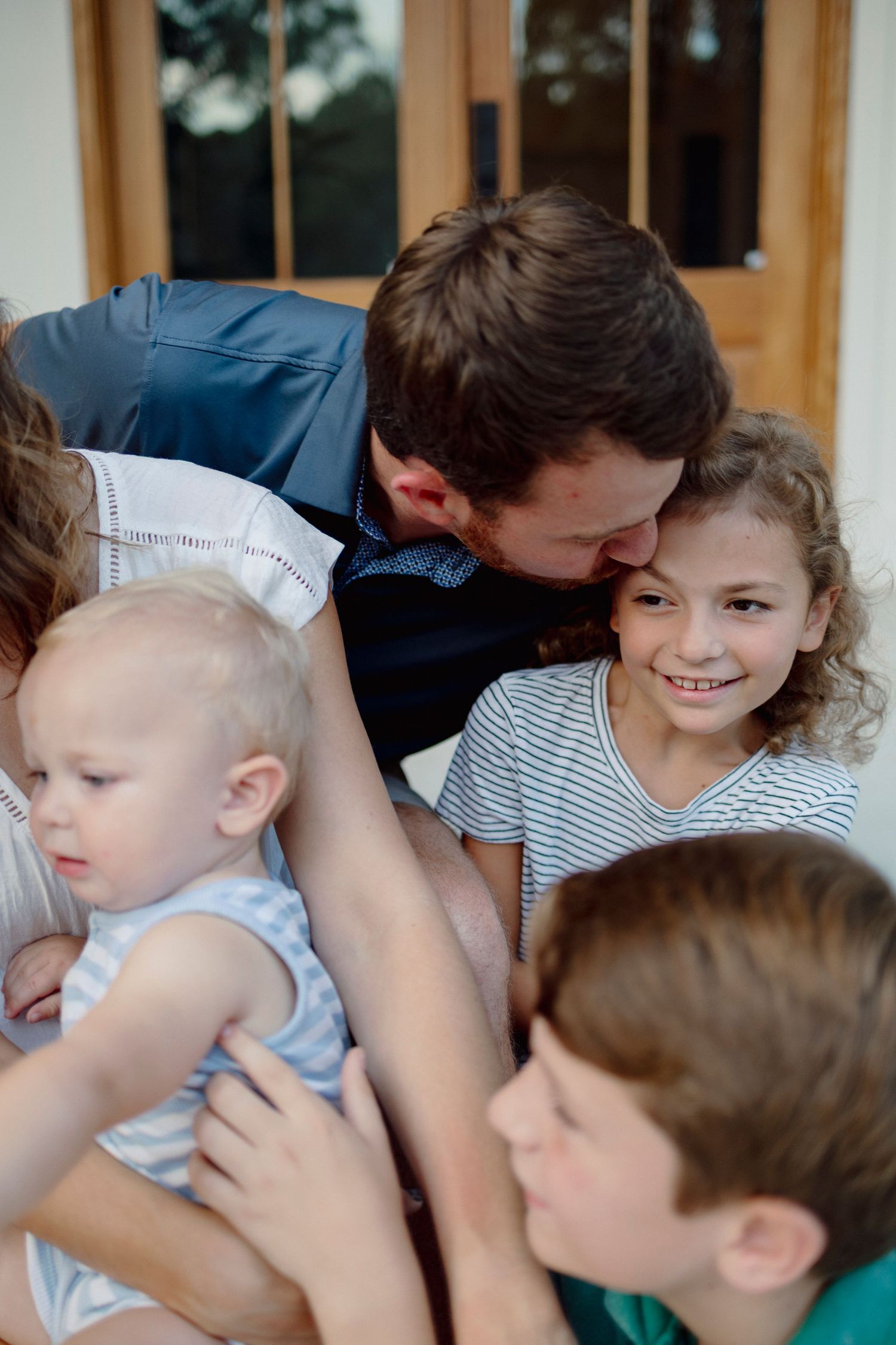 Children in casual clothing gather close together in a candid group photo showing joyful expressions and interaction.