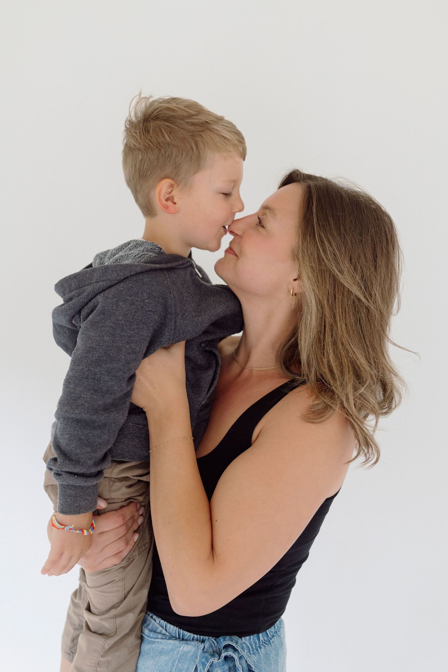 A tender moment between mother and son against a white background in three sequential photos.