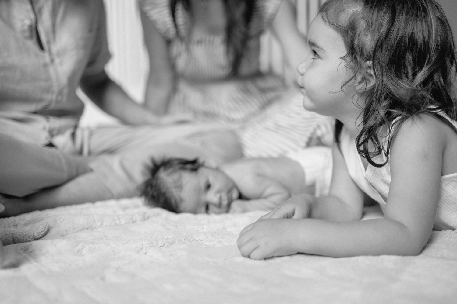 Black and white photo series showing tender moments between a dog and a young child playing together on a bed.