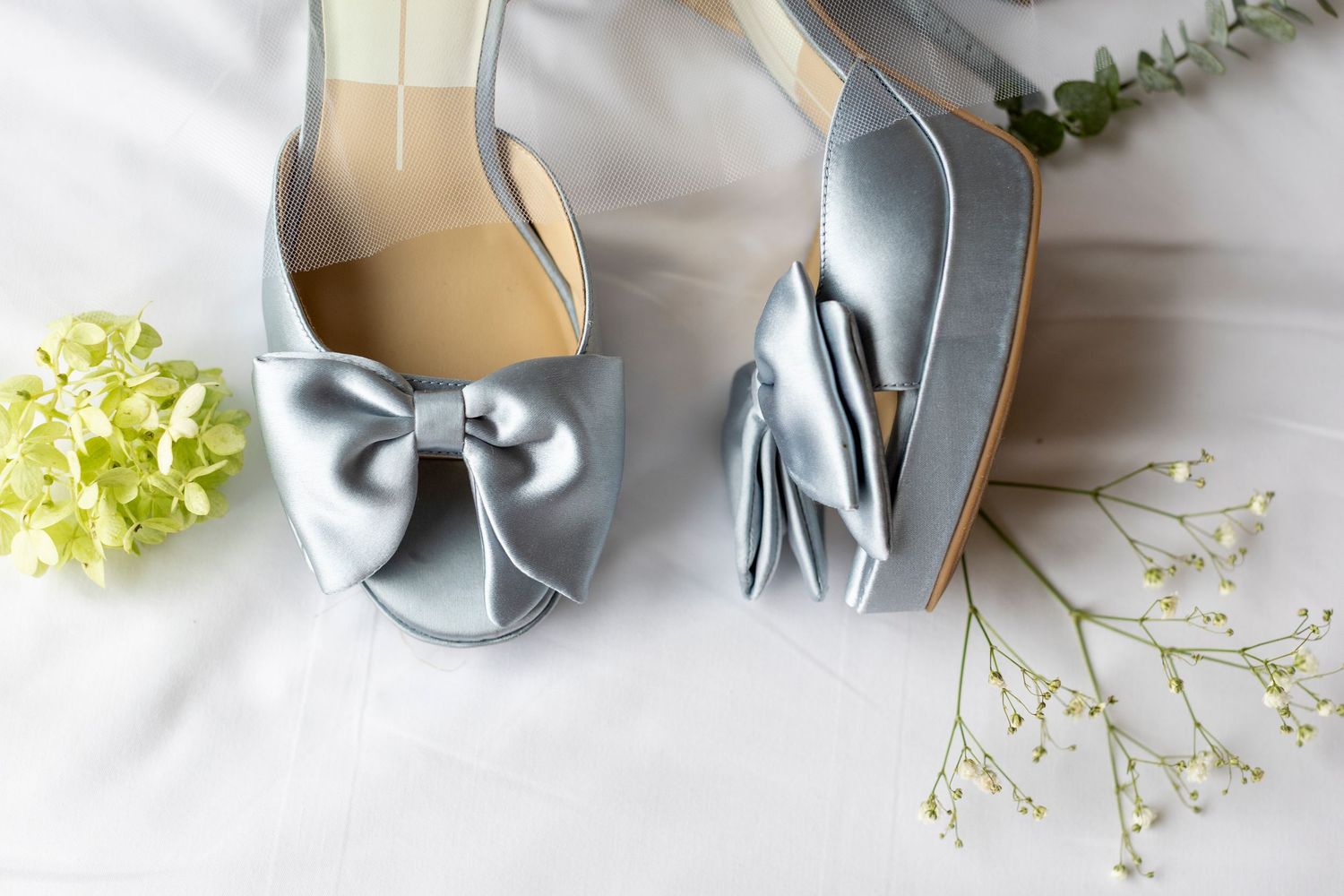 Wedding detail shot of silver metal heart-shaped cookie cutters with delicate white flowers.