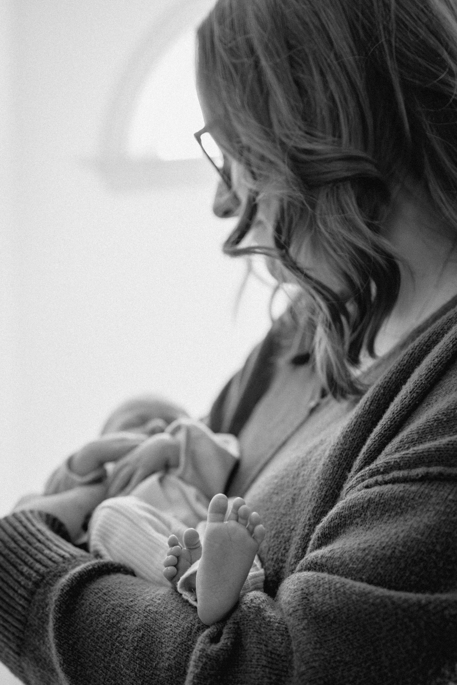 A tender black and white photo series showing a mother nursing and bonding with her newborn baby.