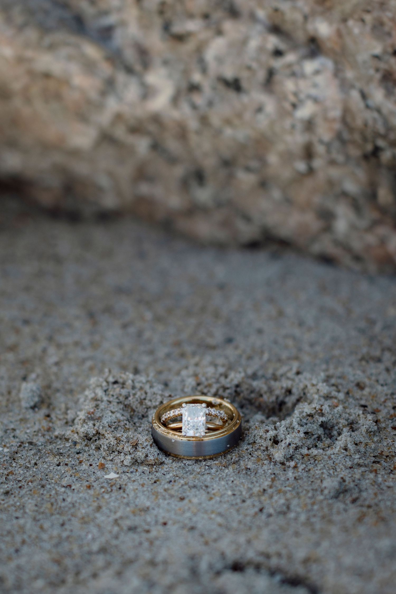 Three close-up shots of wedding rings with diamonds on a textured stone surface showing different angles and details.