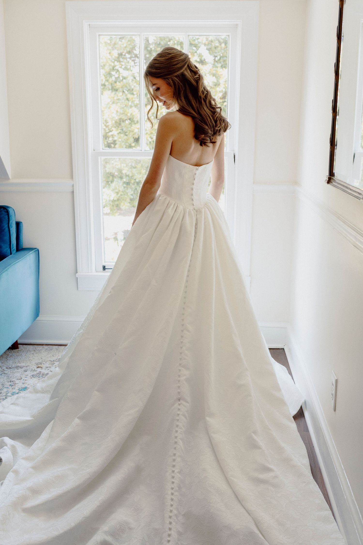 Back view of bride in flowing ballgown wedding dress with button details.