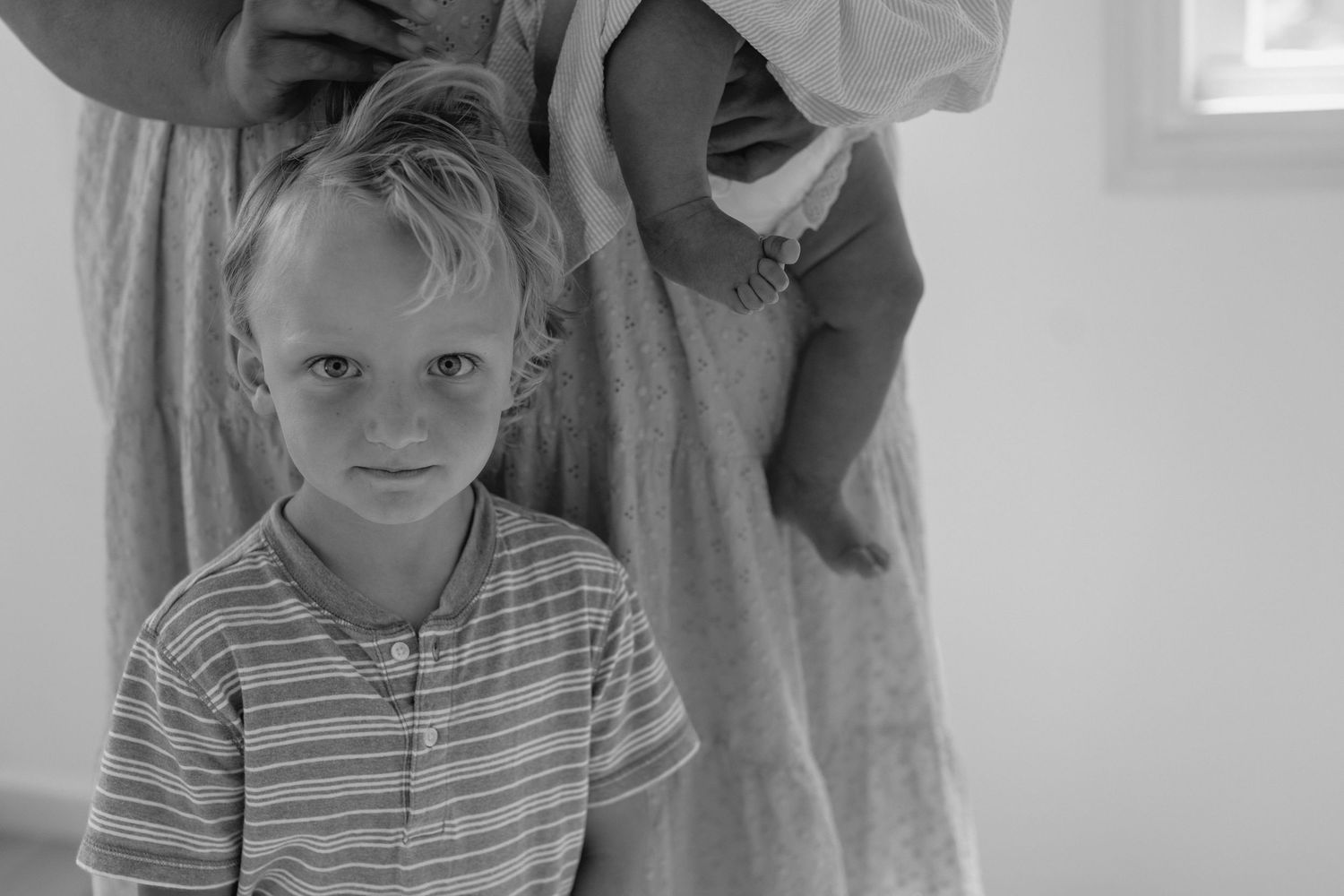Casual indoor family scene with natural lighting and white walls.