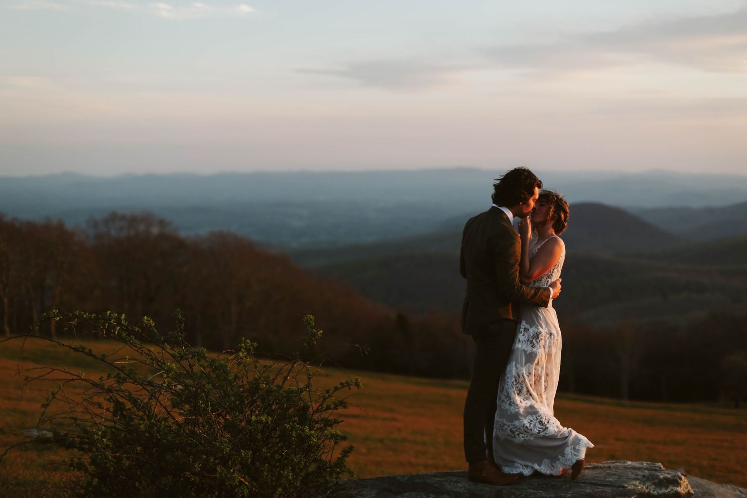 Scenic mountain vista at sunset with rolling hills stretching to the horizon.