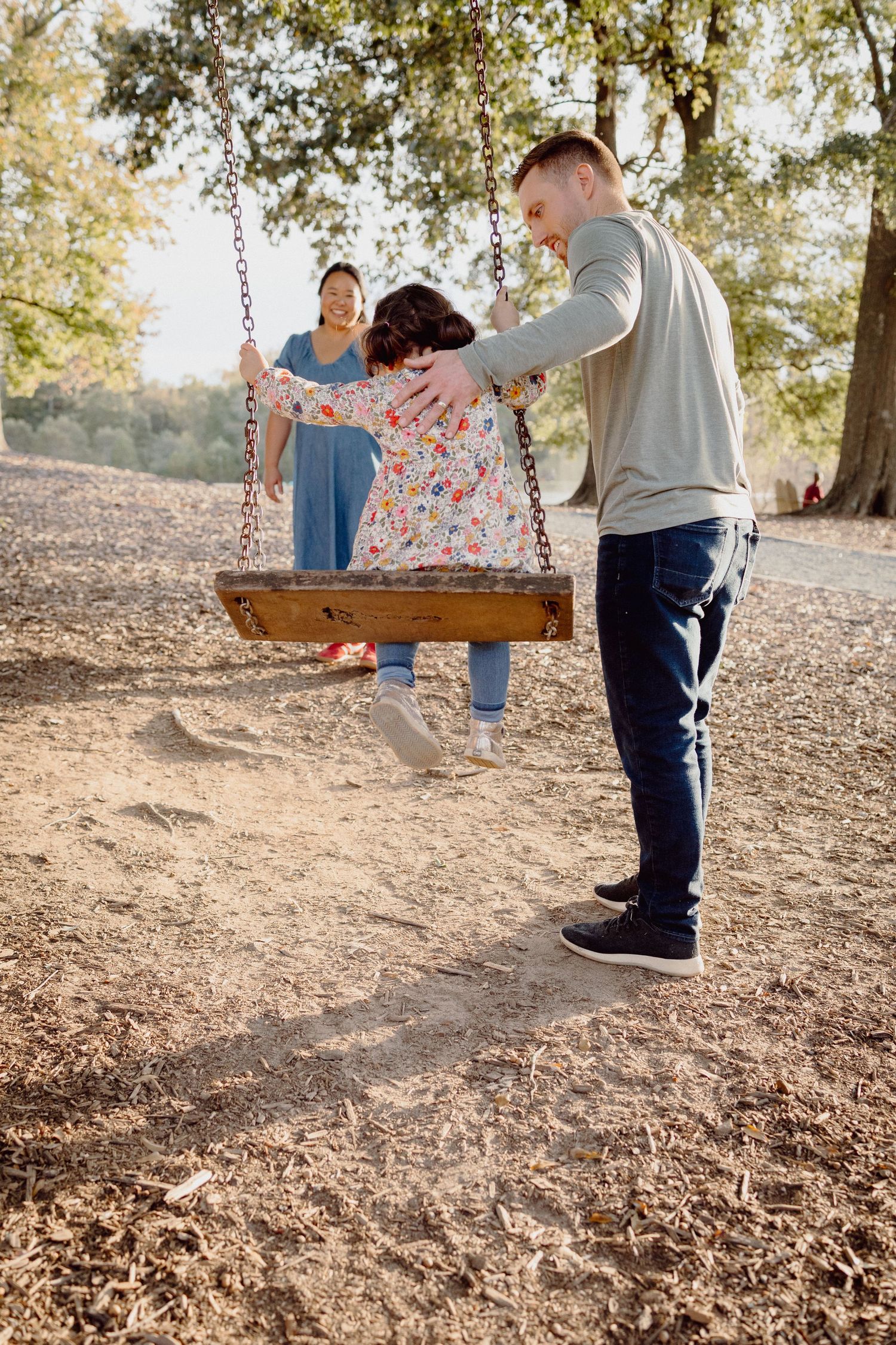 A series of photos showing a couple enjoying a romantic moment together on a swing in a sunlit outdoor setting.