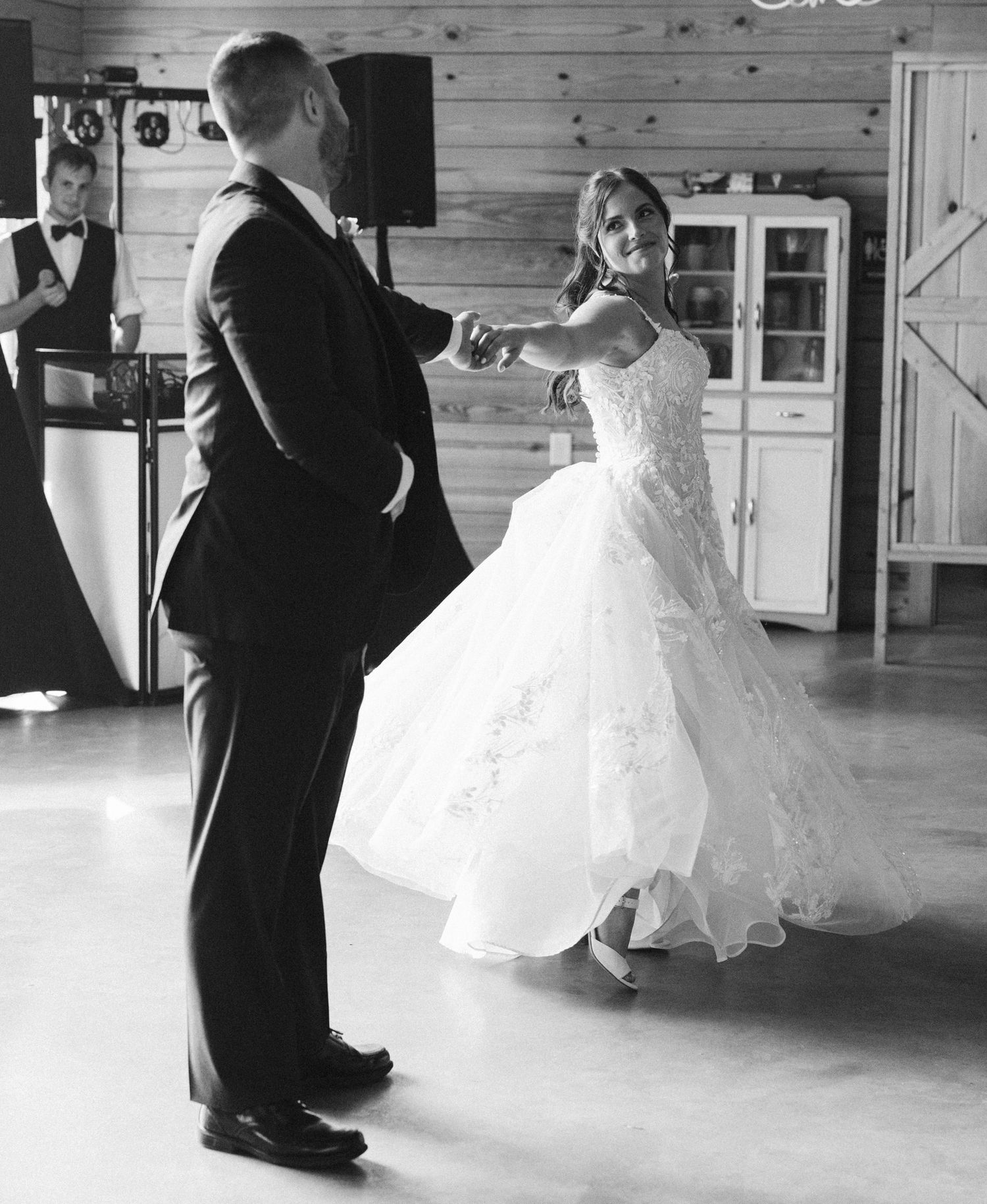 Black and white photos of couple dancing in rustic wooden venue.