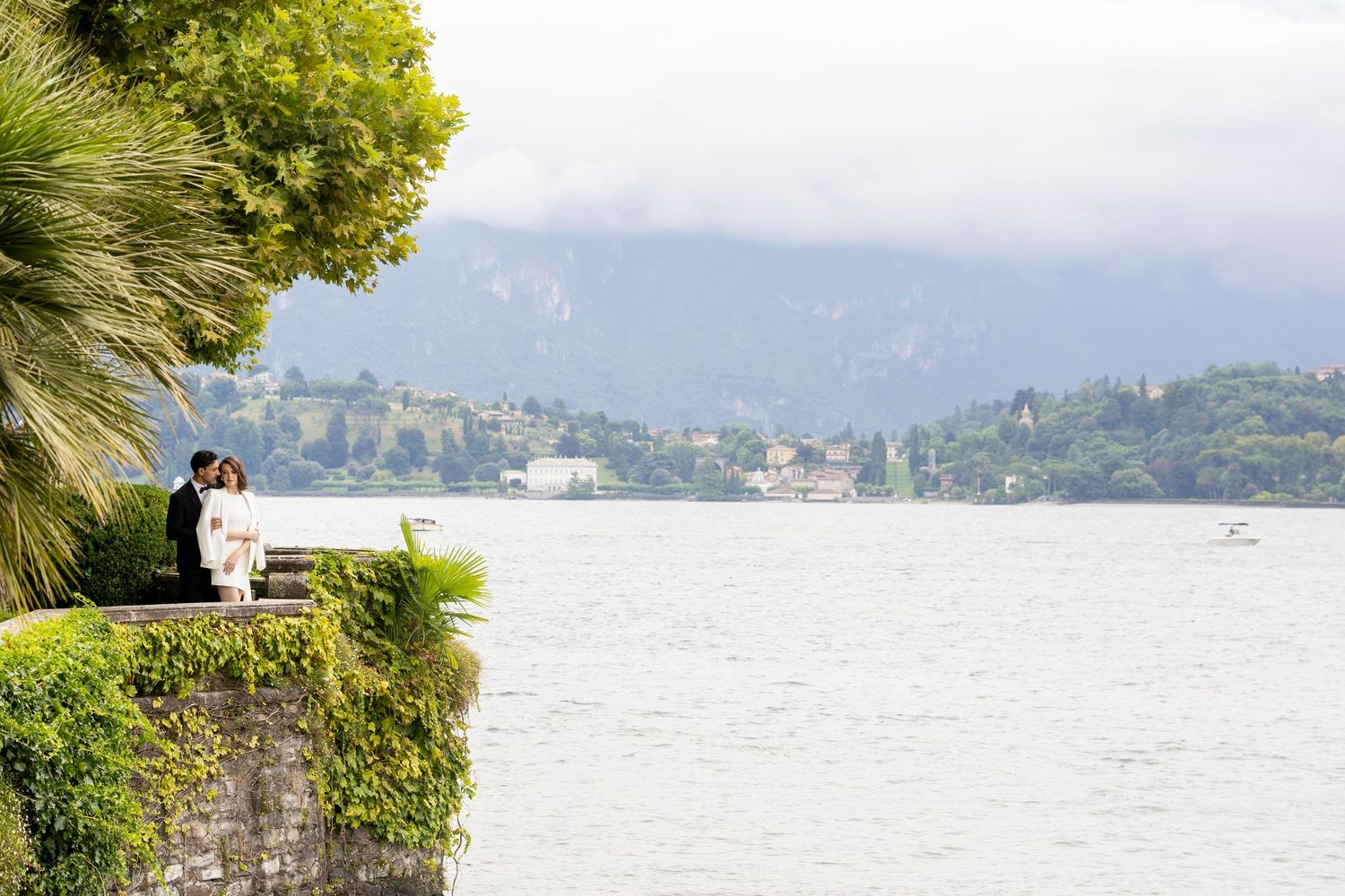 Scenic waterfront view with mountains and trees along the shoreline.
