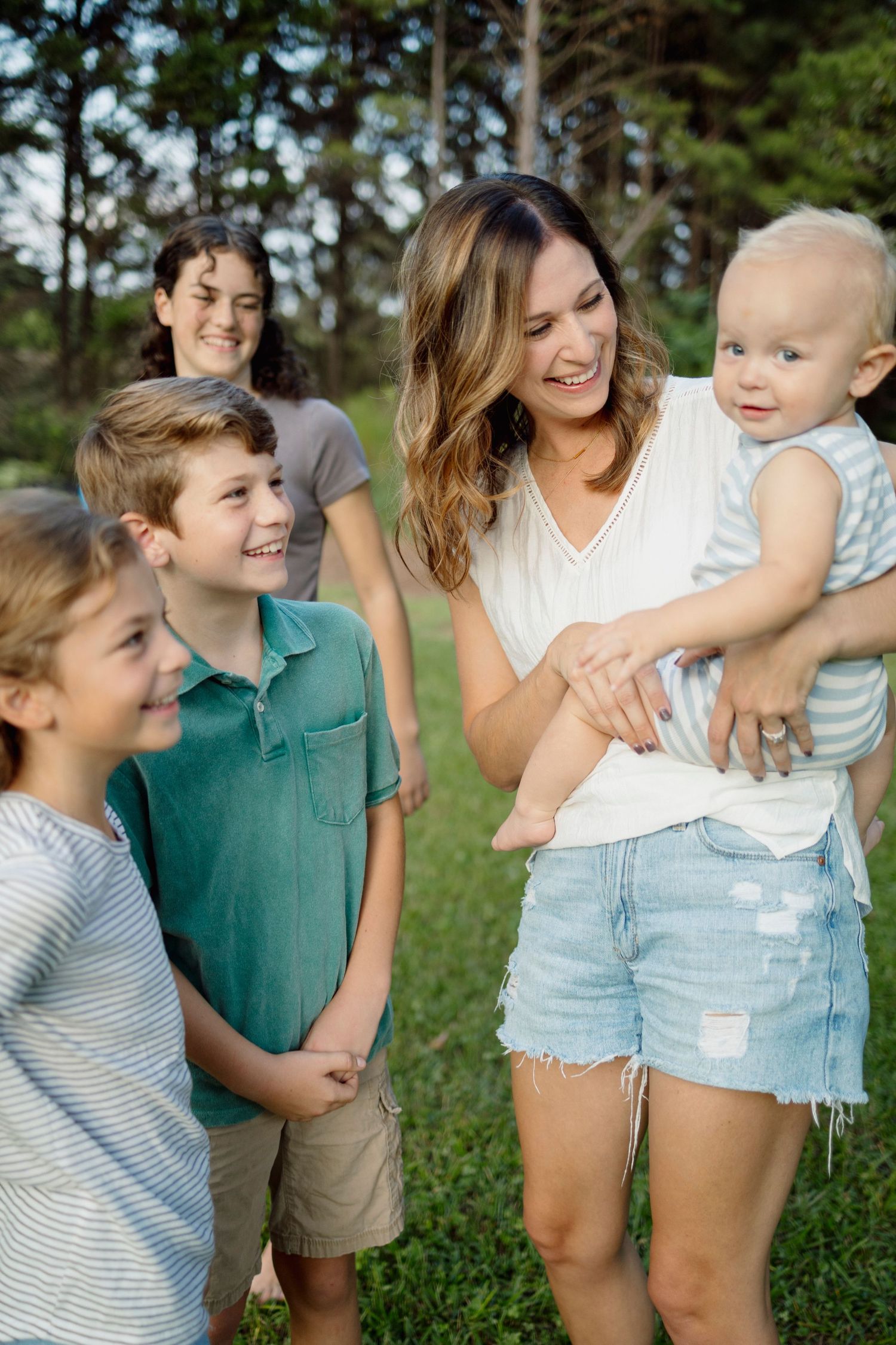 A happy family spending time together outdoors on a sunny day, sharing smiles and laughter in a natural setting.