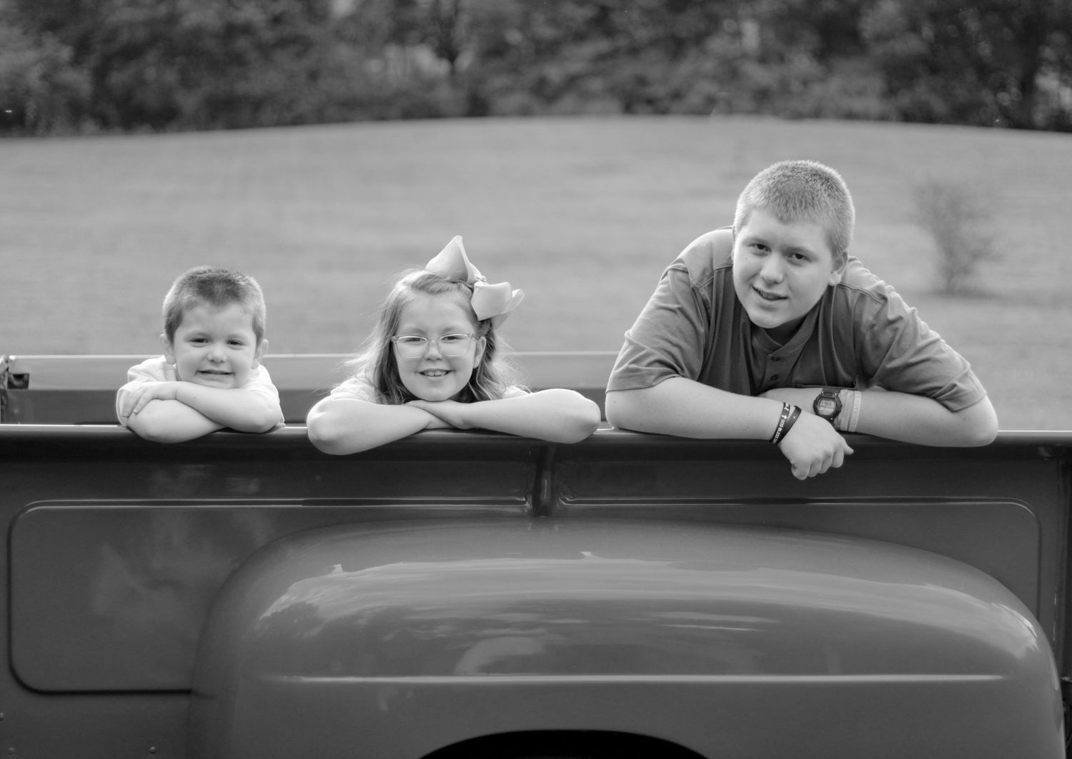Black and white family portraits arranged around an old pickup truck.