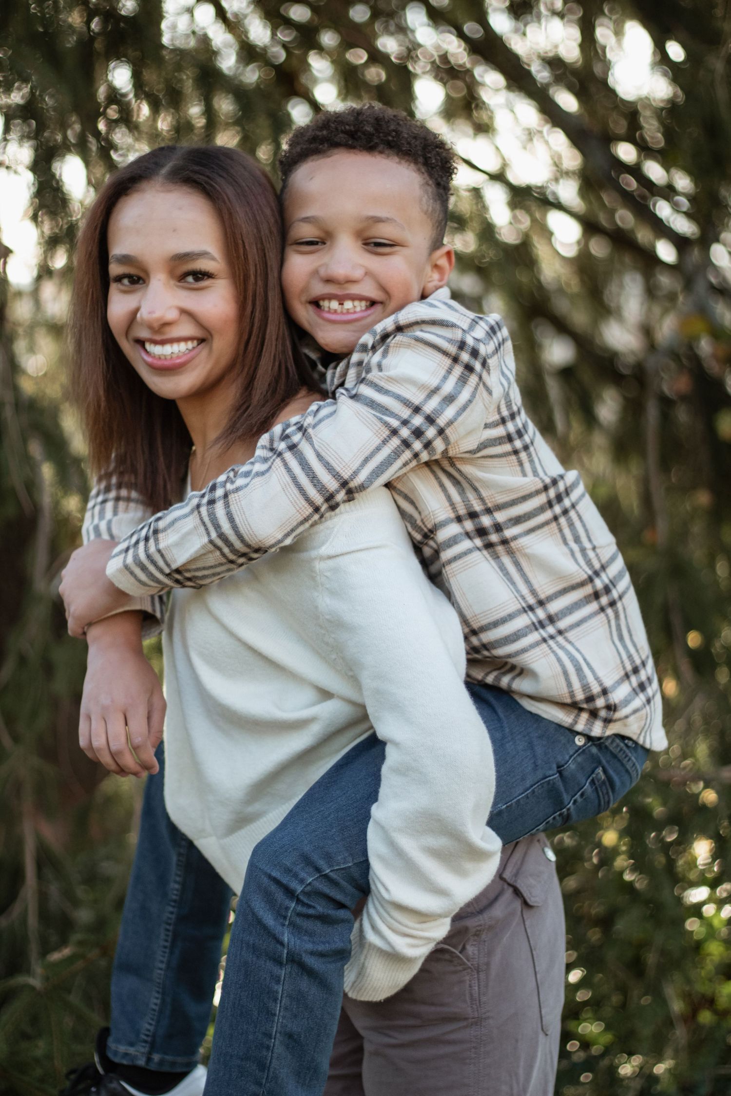 Playful outdoor family photos showing joyful piggyback ride moments.