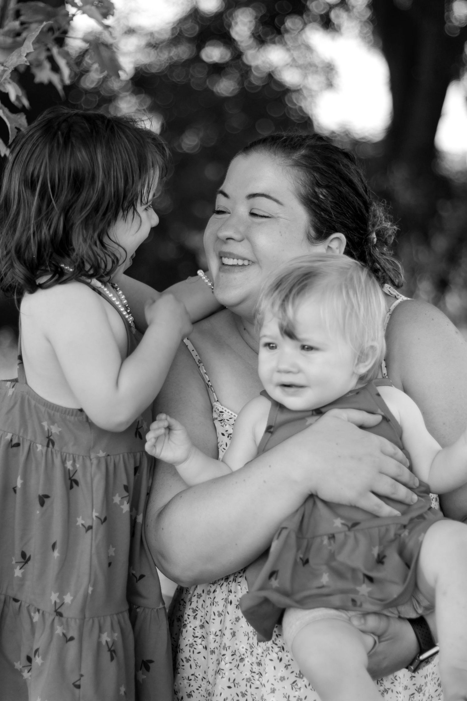A touching black and white photo series showing a tender moment between parent and child in an outdoor setting.