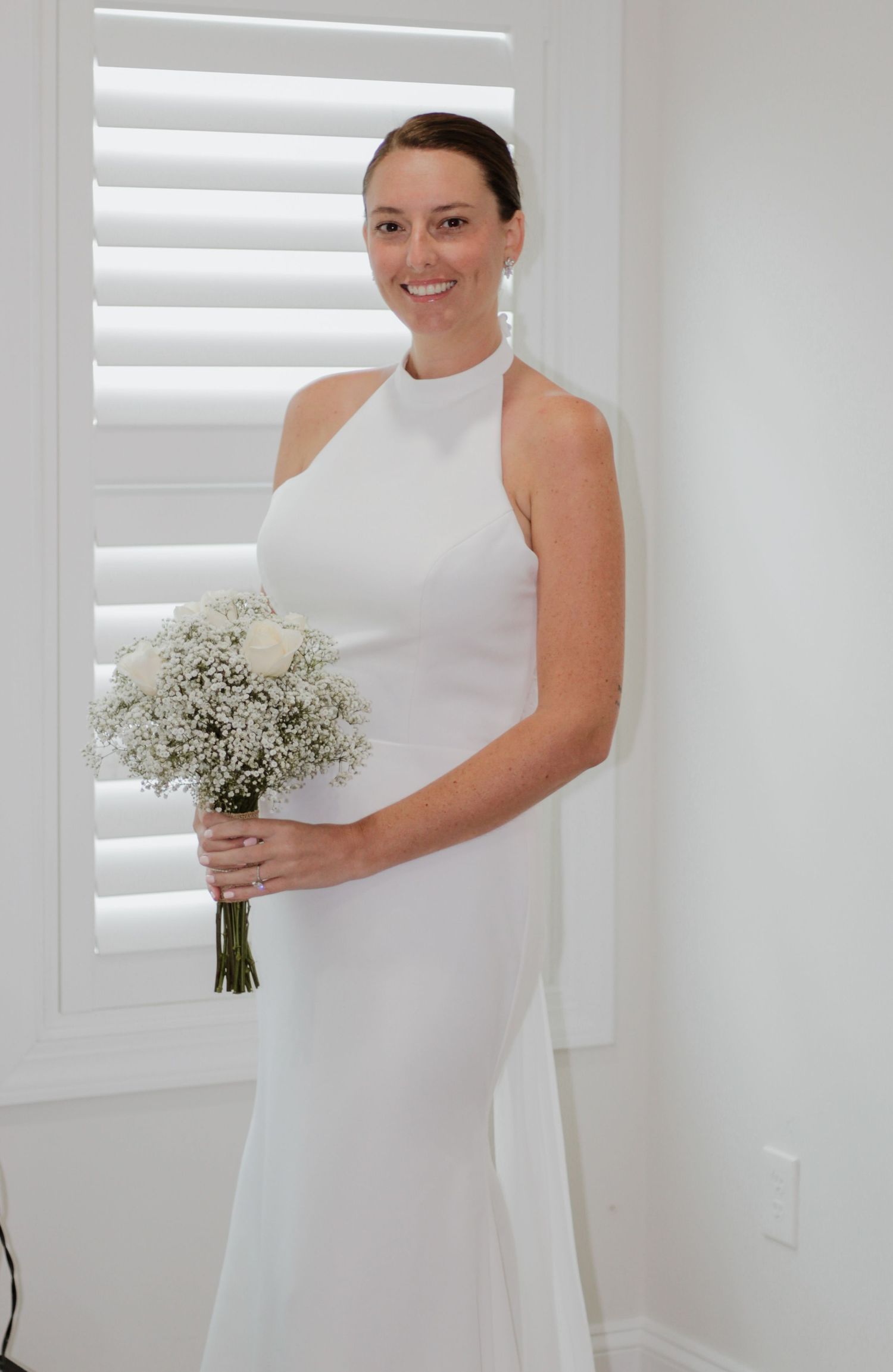 Wedding bouquet of white baby's breath flowers held in natural light setting.