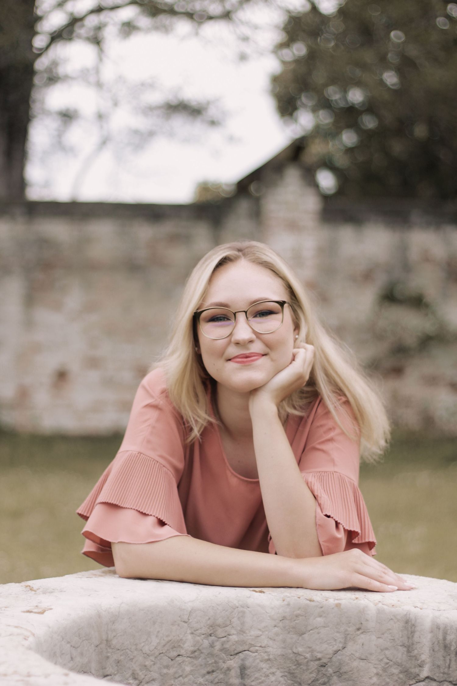 Casual portrait poses against stone wall in outdoor setting.