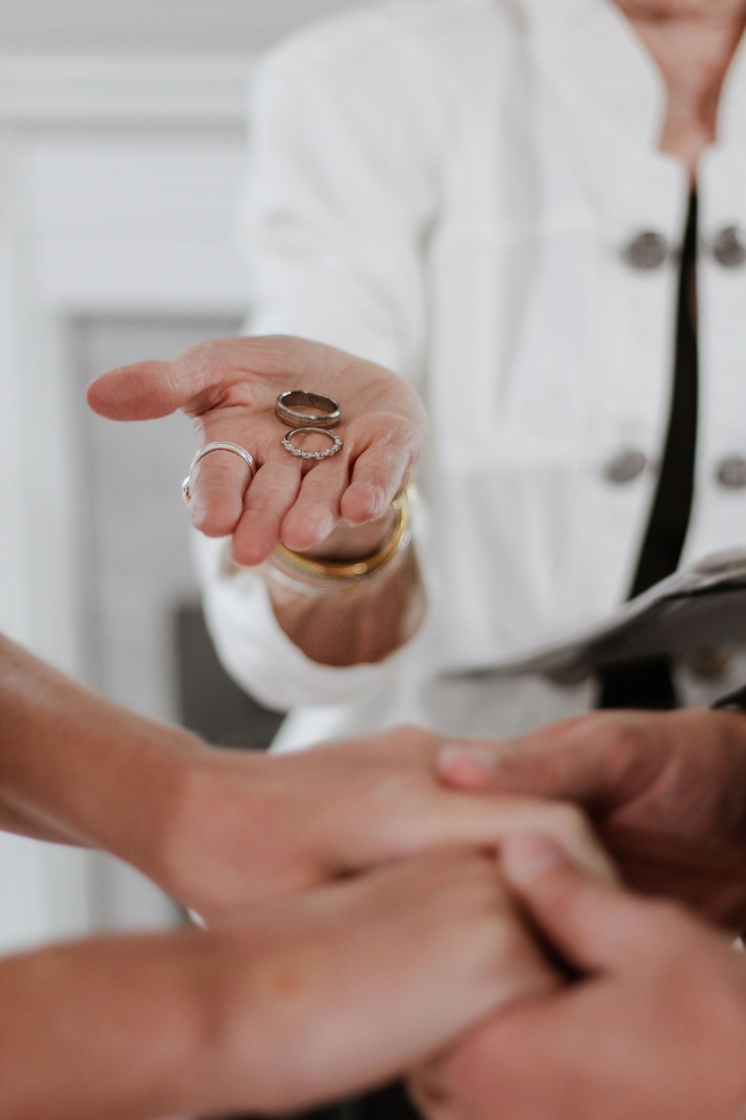 Hands exchanging wedding rings during ceremony closeup shot.