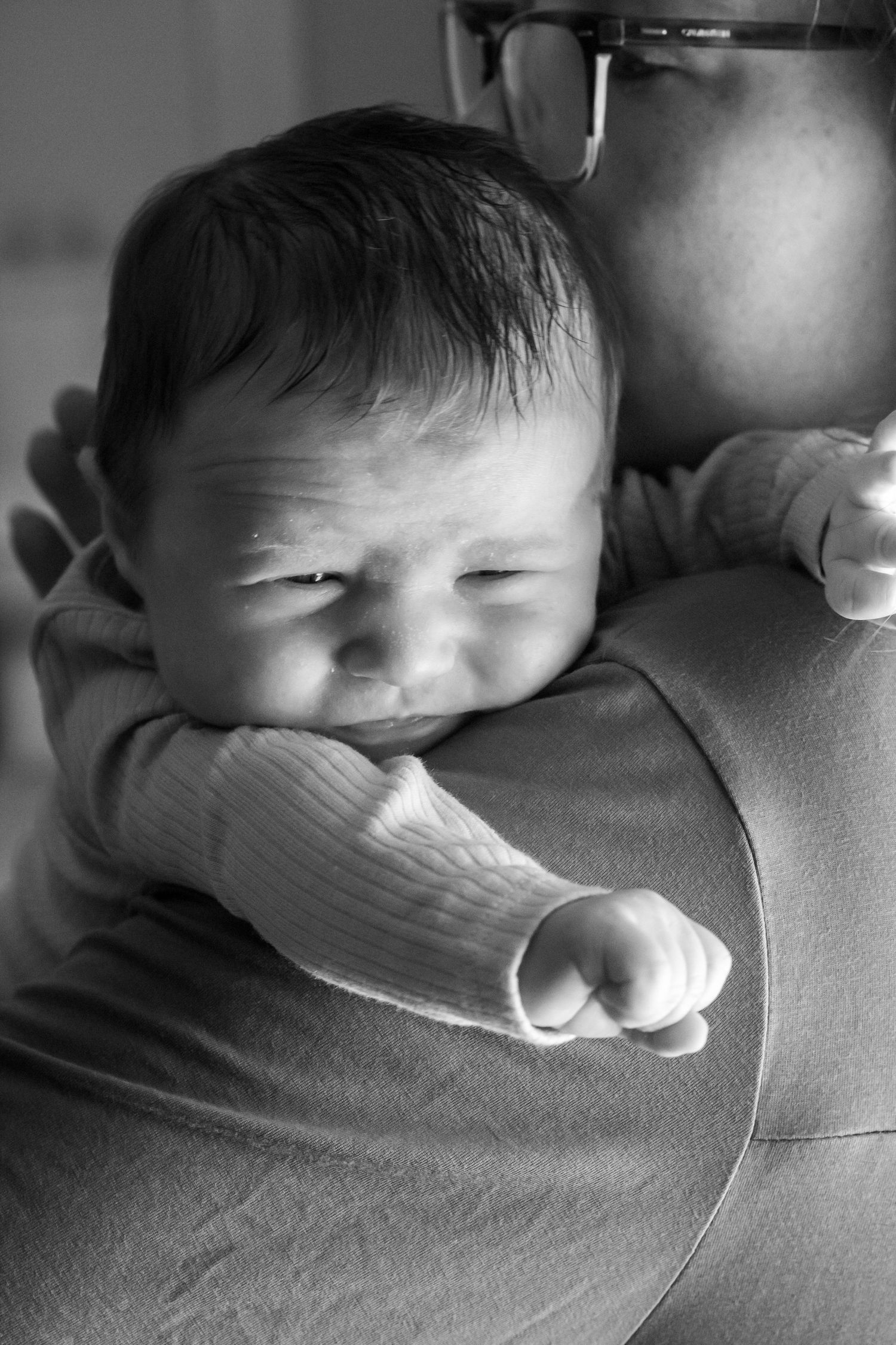 Black and white series of a sleeping infant resting peacefully on soft fabric.