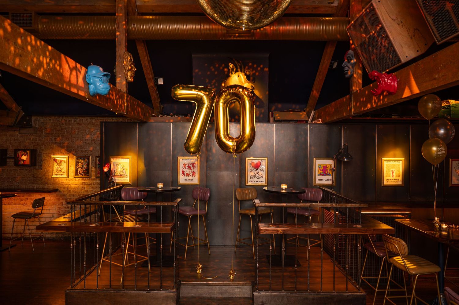 Stylish bar venue decorated with gold number 70 balloons for a milestone birthday celebration.