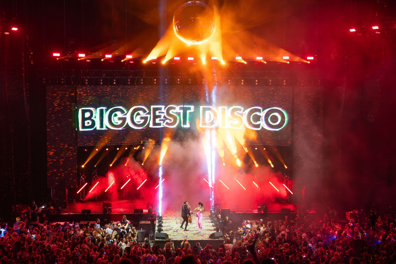 Biggest Disco live show with dramatic red lighting and smoke effects on a grand stage.