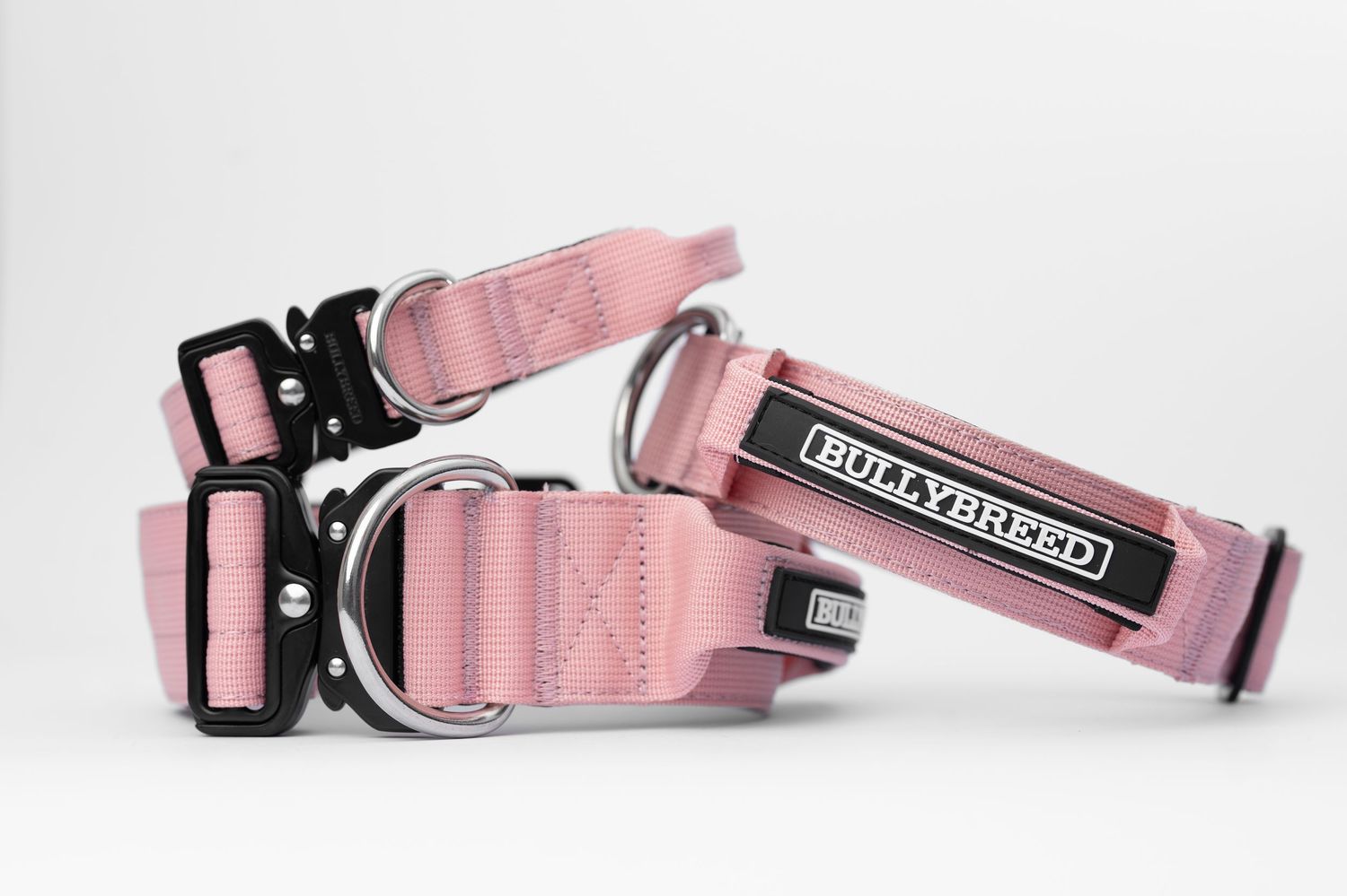 Two pink BullyBreed dog collars with black hardware and metal D-rings displayed on a white background.