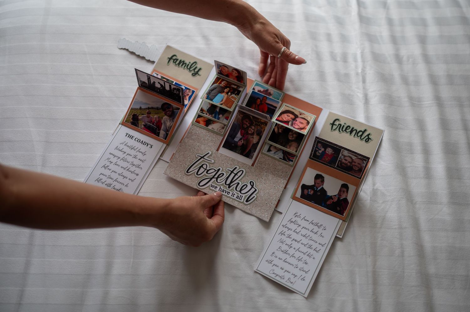 Handmade scrapbook with family and friends photos, featuring together theme, displayed on white bed.