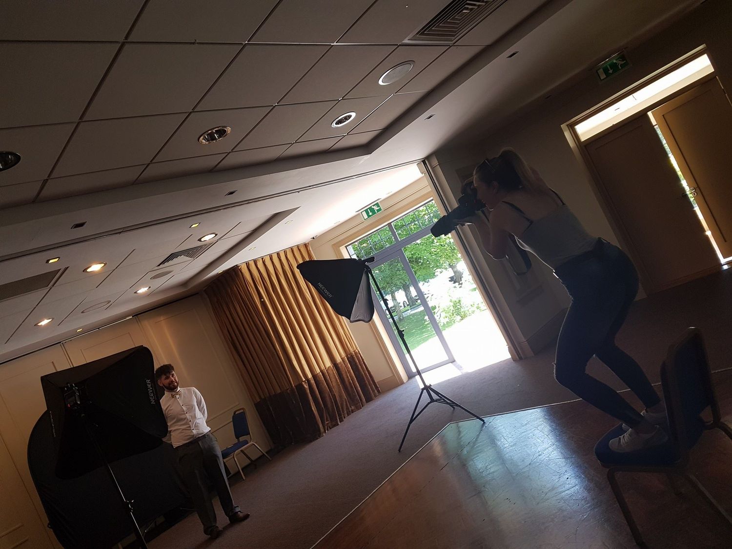 Photographer capturing a subject during an indoor professional photo shoot session in a conference room.