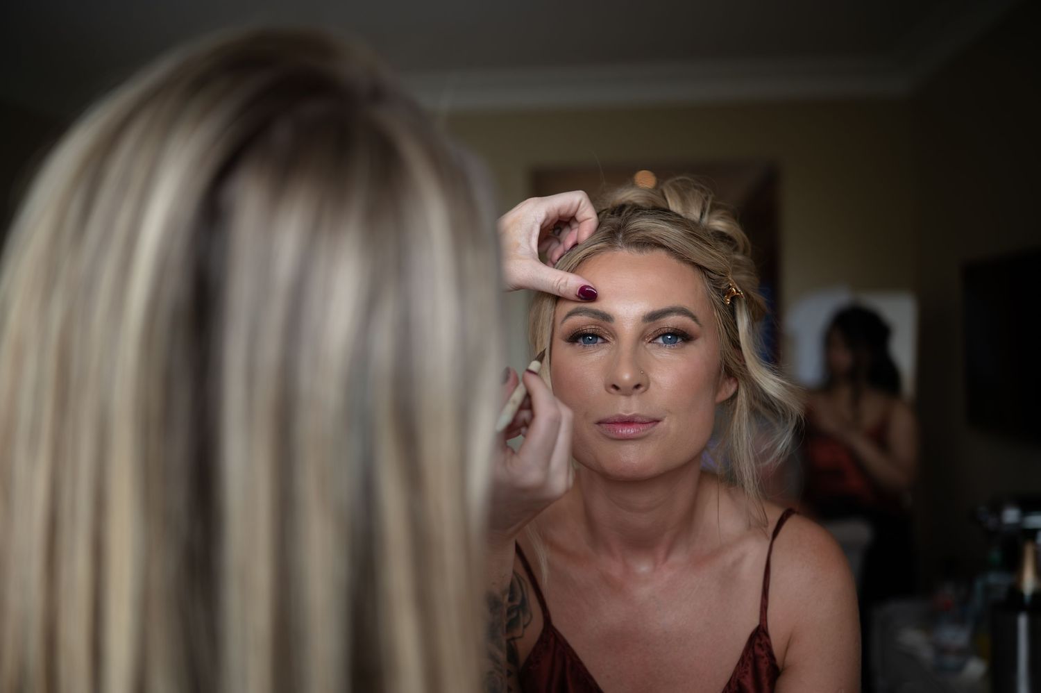 Bride getting makeup applied by a professional artist before her wedding ceremony.