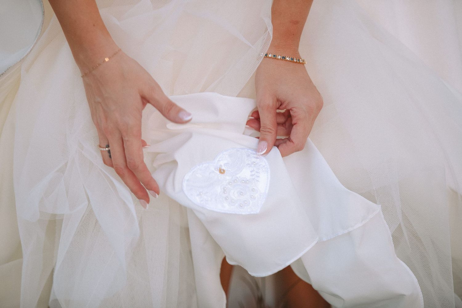 Bride holding a white lace handkerchief with sand dollar detail in her lap.