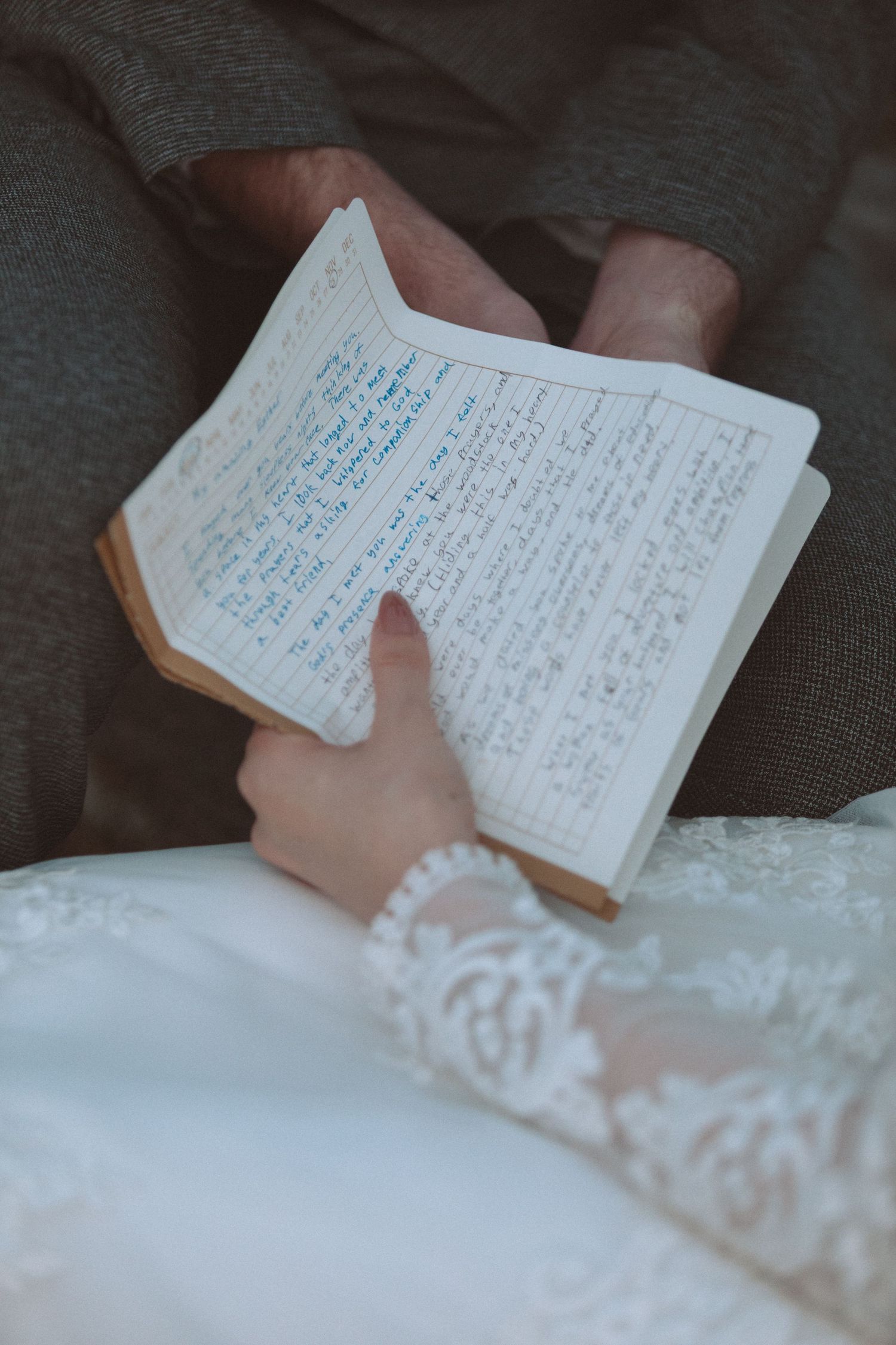 Bride and groom share handwritten wedding vows journal during intimate wedding ceremony moment.
