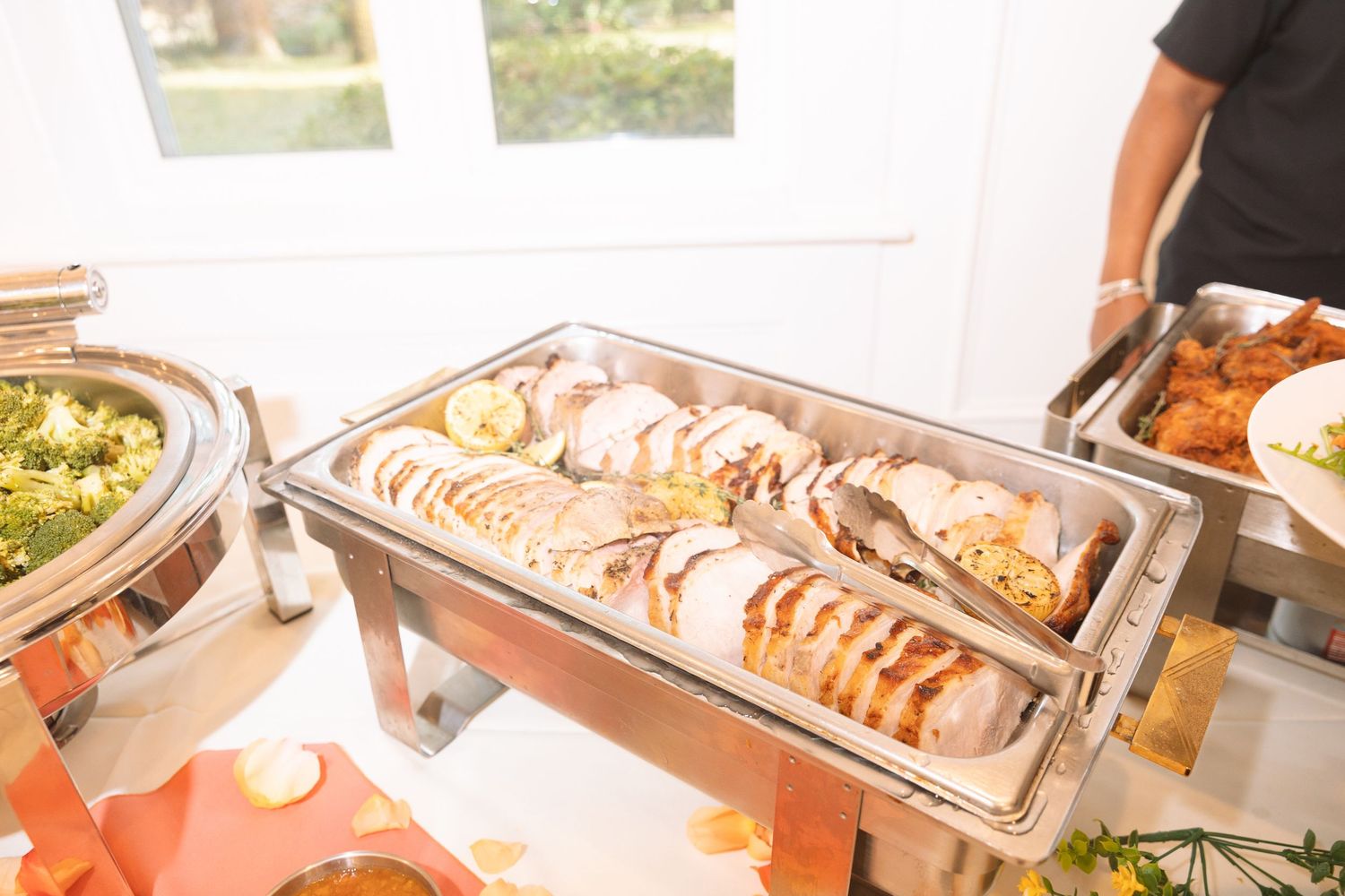 Close-up of chafing dish filled with sliced stuffed chicken at a catered buffet event.
