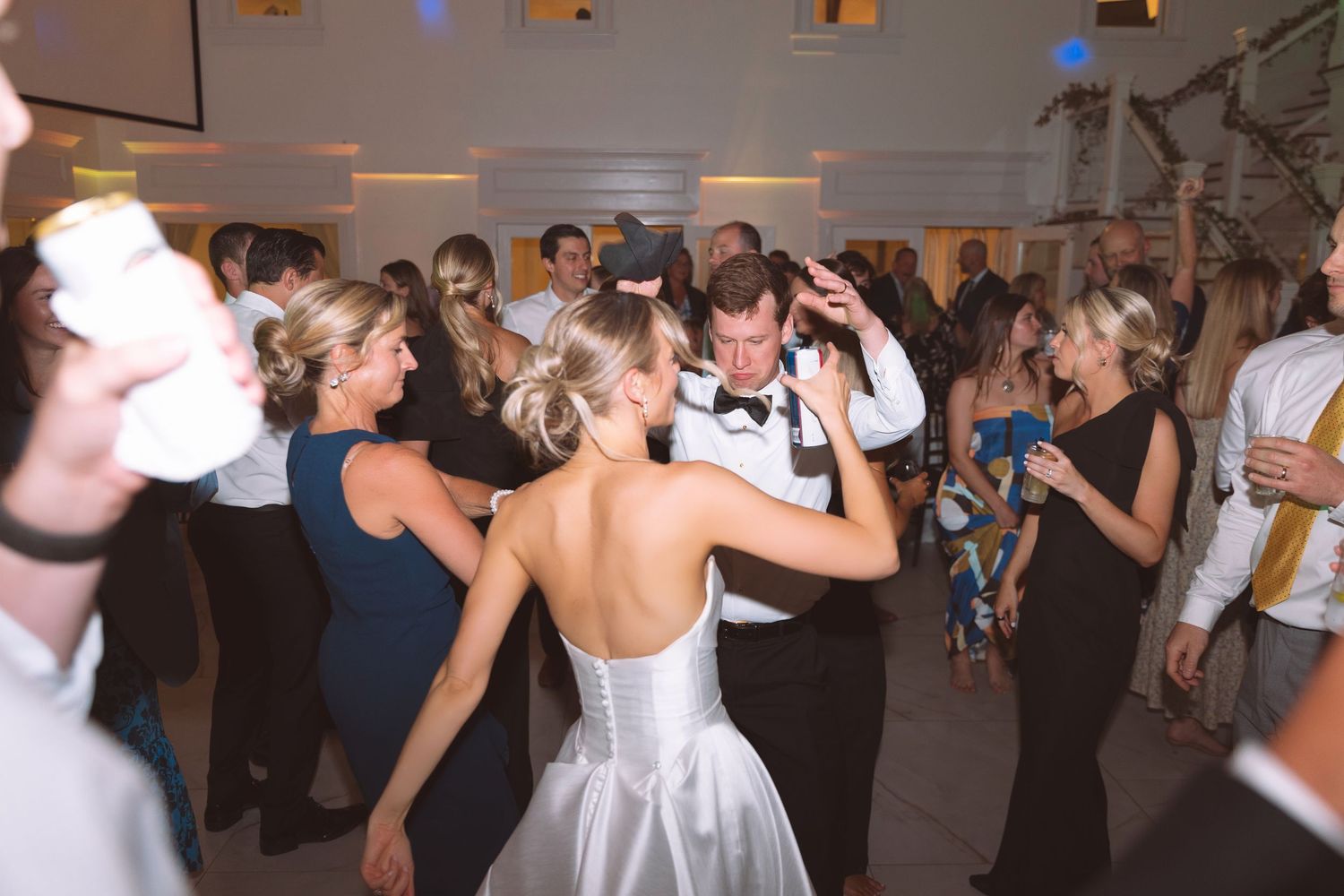 Bride and groom share a dance surrounded by guests at their wedding reception.