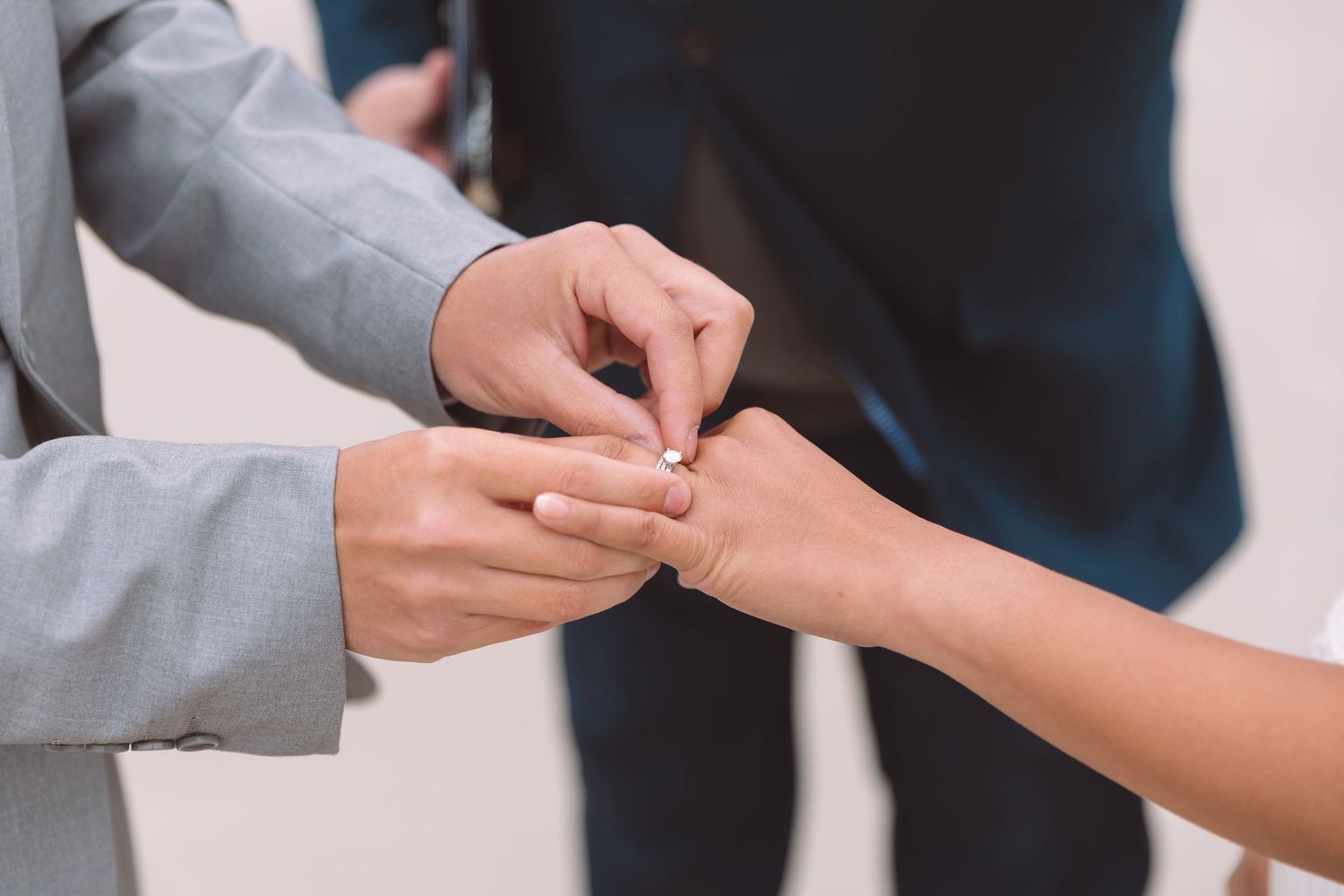 Groom places wedding ring on brides finger during intimate outdoor elopement ceremony.