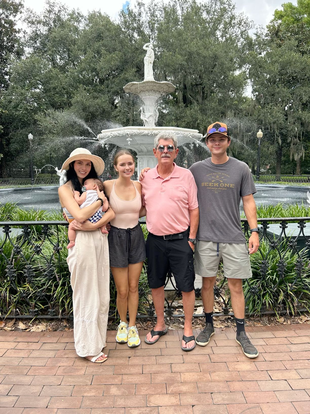 Family of four posing in front of Forsyth Park fountain in Savannah Georgia.