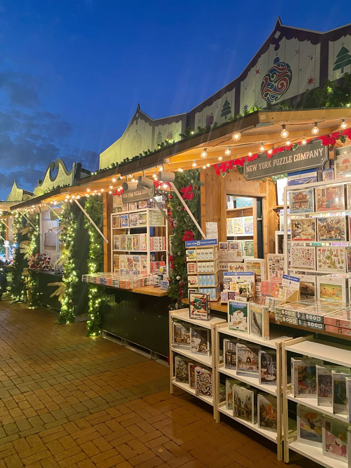New York Puzzle Company booth at a Christmas market with colorful puzzles.