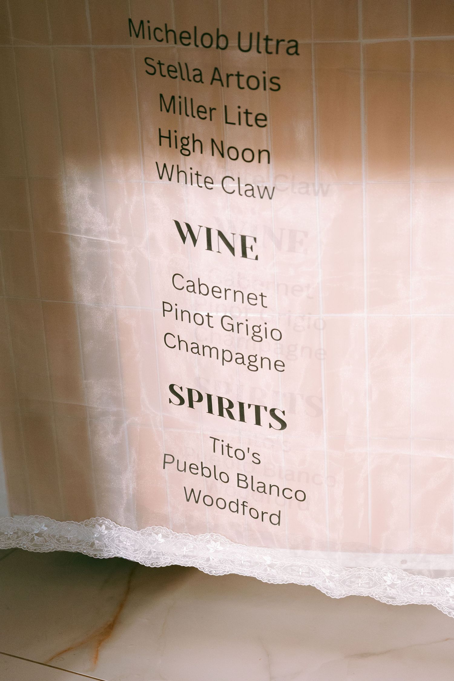 Wedding bar menu sign listing beers, wines, and spirits including Titos and Woodford Reserve.
